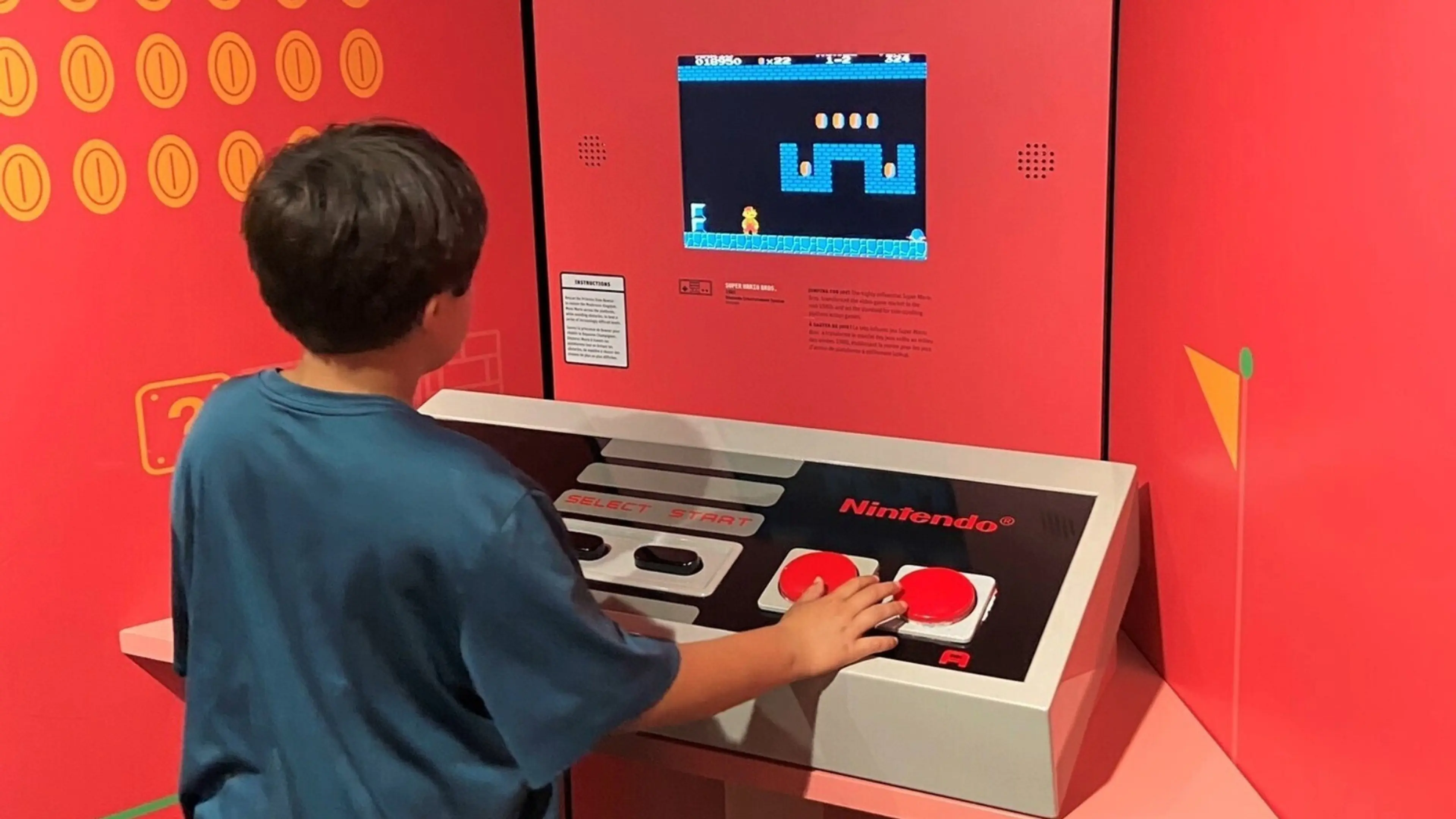A child playing a classic Nintendo video game on a large console with a screen showing a pixelated game scene.