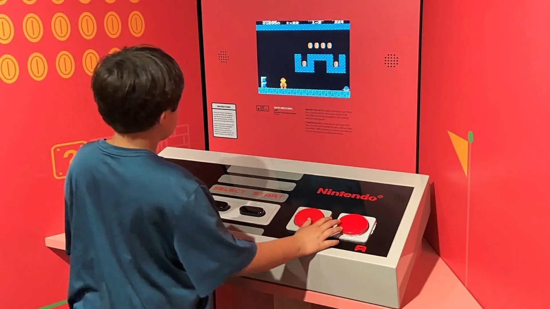 A child playing a classic Nintendo video game on a large console with a screen showing a pixelated game scene.
