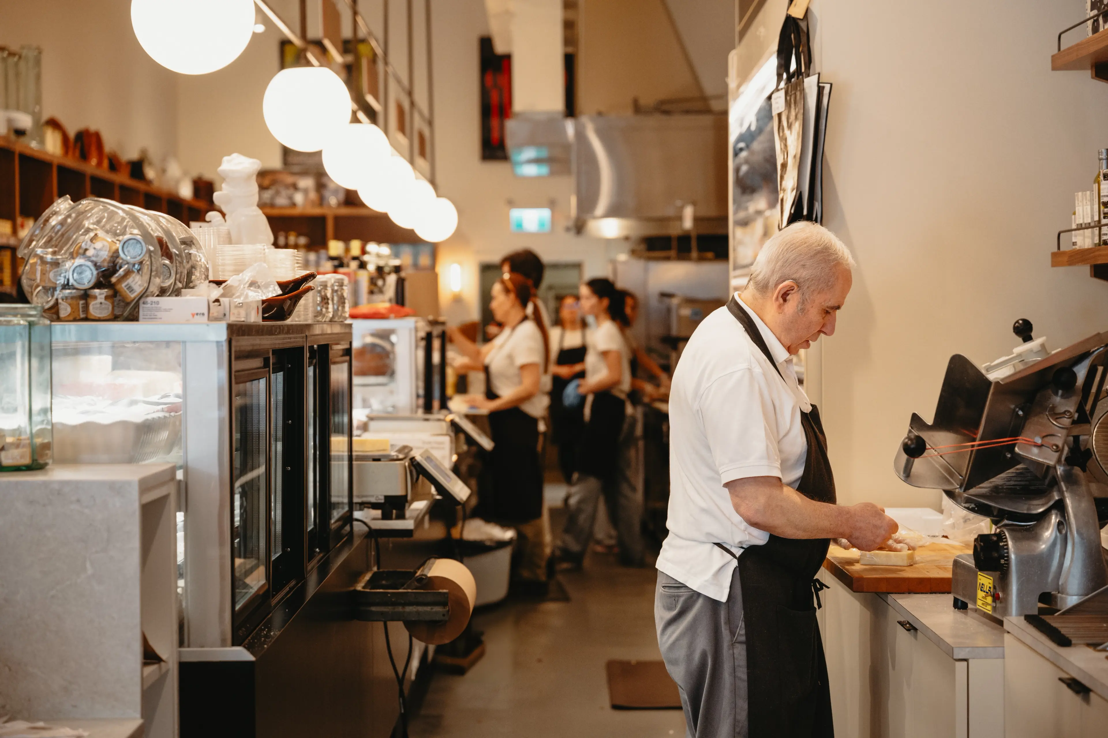 Interior image with chef preparing sandwiches at La Grotta Del Formaggio, Vancouver.
