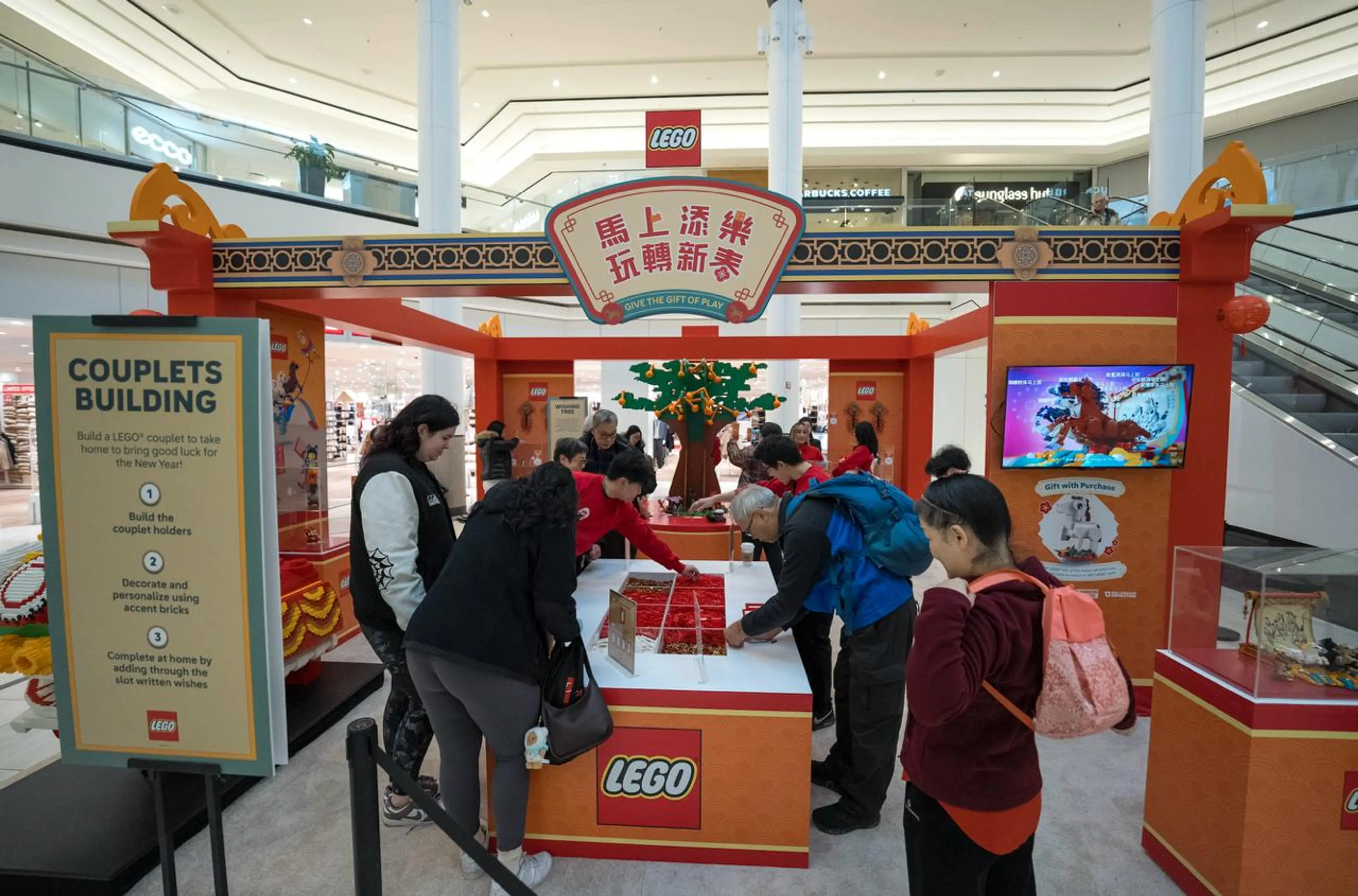 people standing at an interactive table for the LEGO® Lunar New Year Pop-Up in Vancouver.