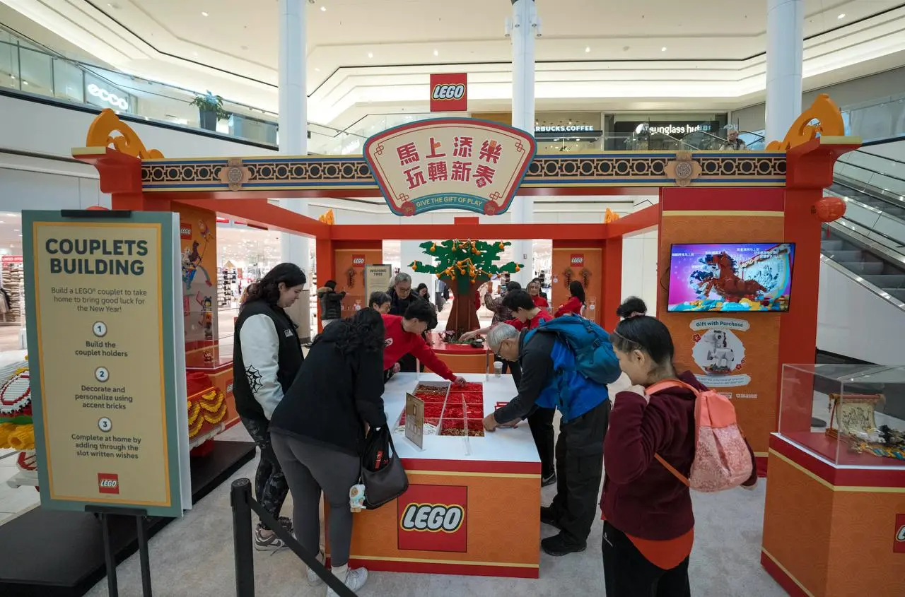 people standing at an interactive table for the LEGO® Lunar New Year Pop-Up in Vancouver.