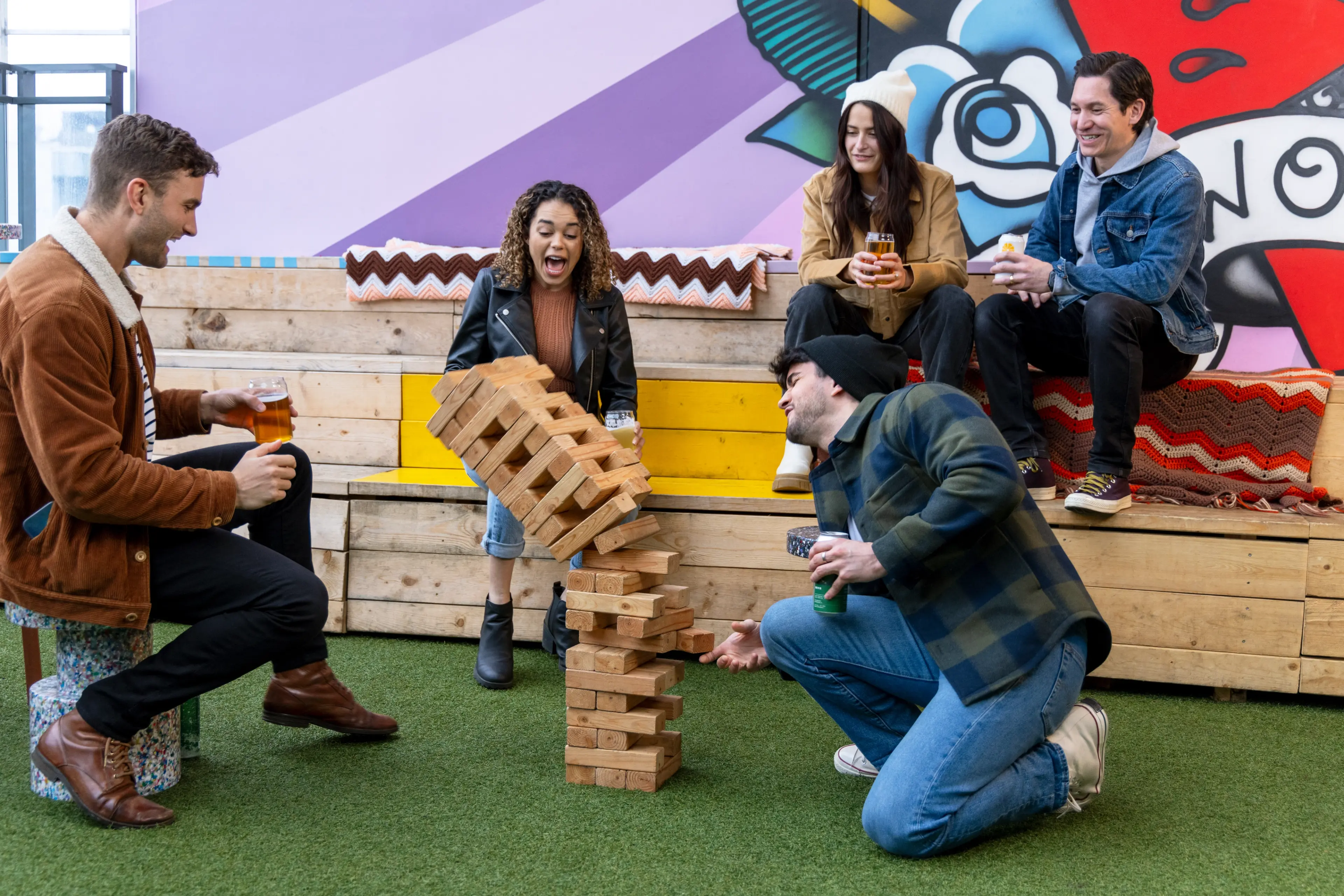 A group of friend playing Jenga at the Vintage and Provisions patio in Mt. Pleasant Vancouver.