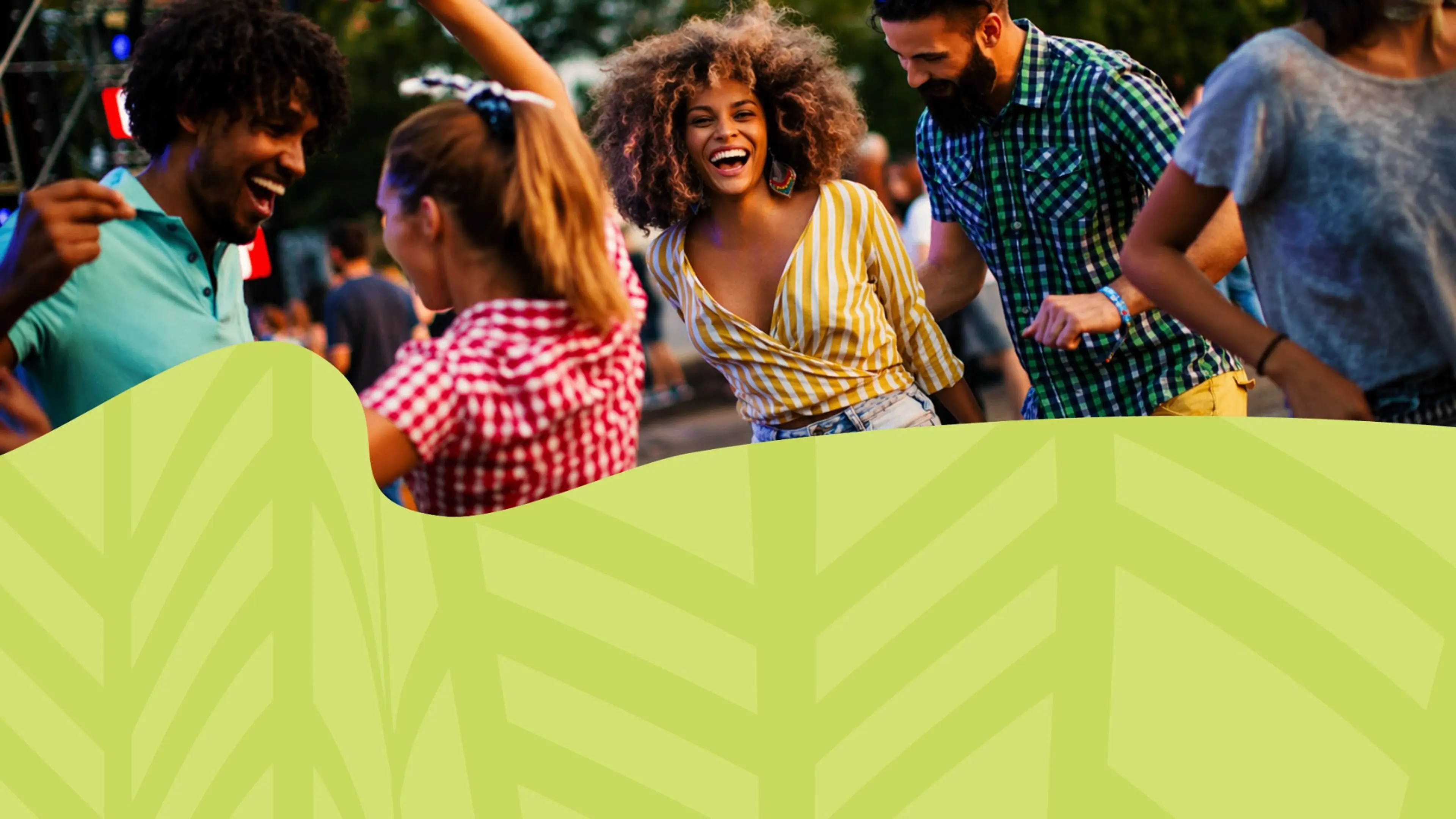 Five people dancing outdoors, one person in a yellow striped shirt smiling at the camera.