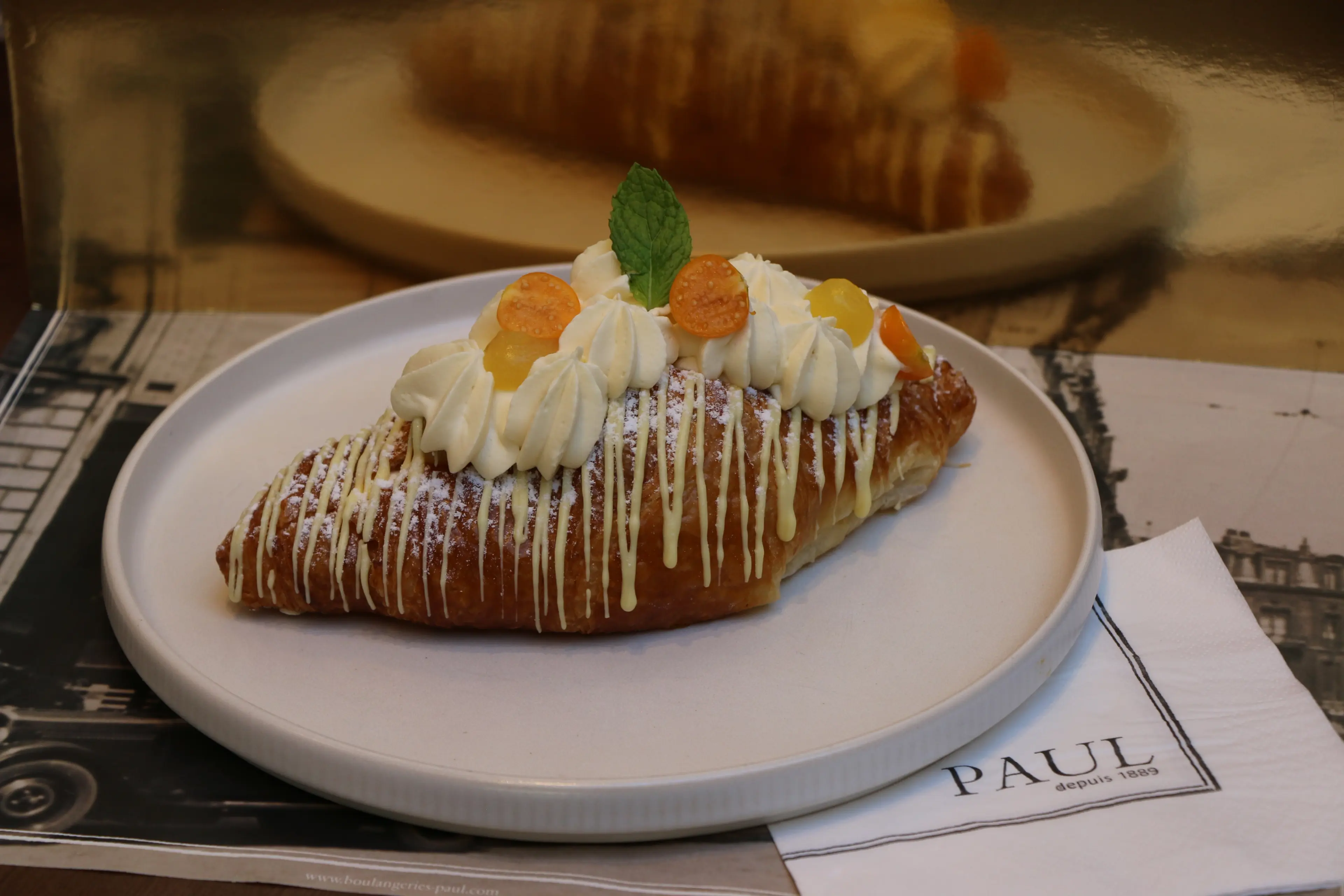 A Pineapple Mango Croissant on a plate at PAUL Robson