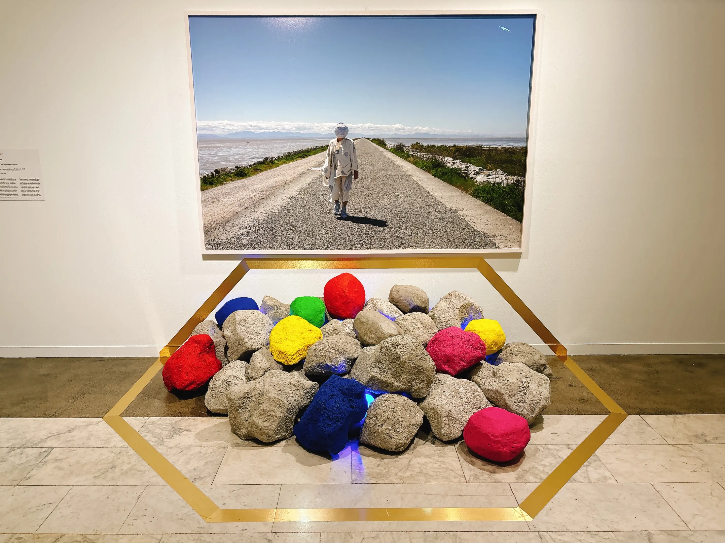Two of Jin-me Yoon's work, one a masked figure on Iona Jetty, the other boulders piled on top of one another