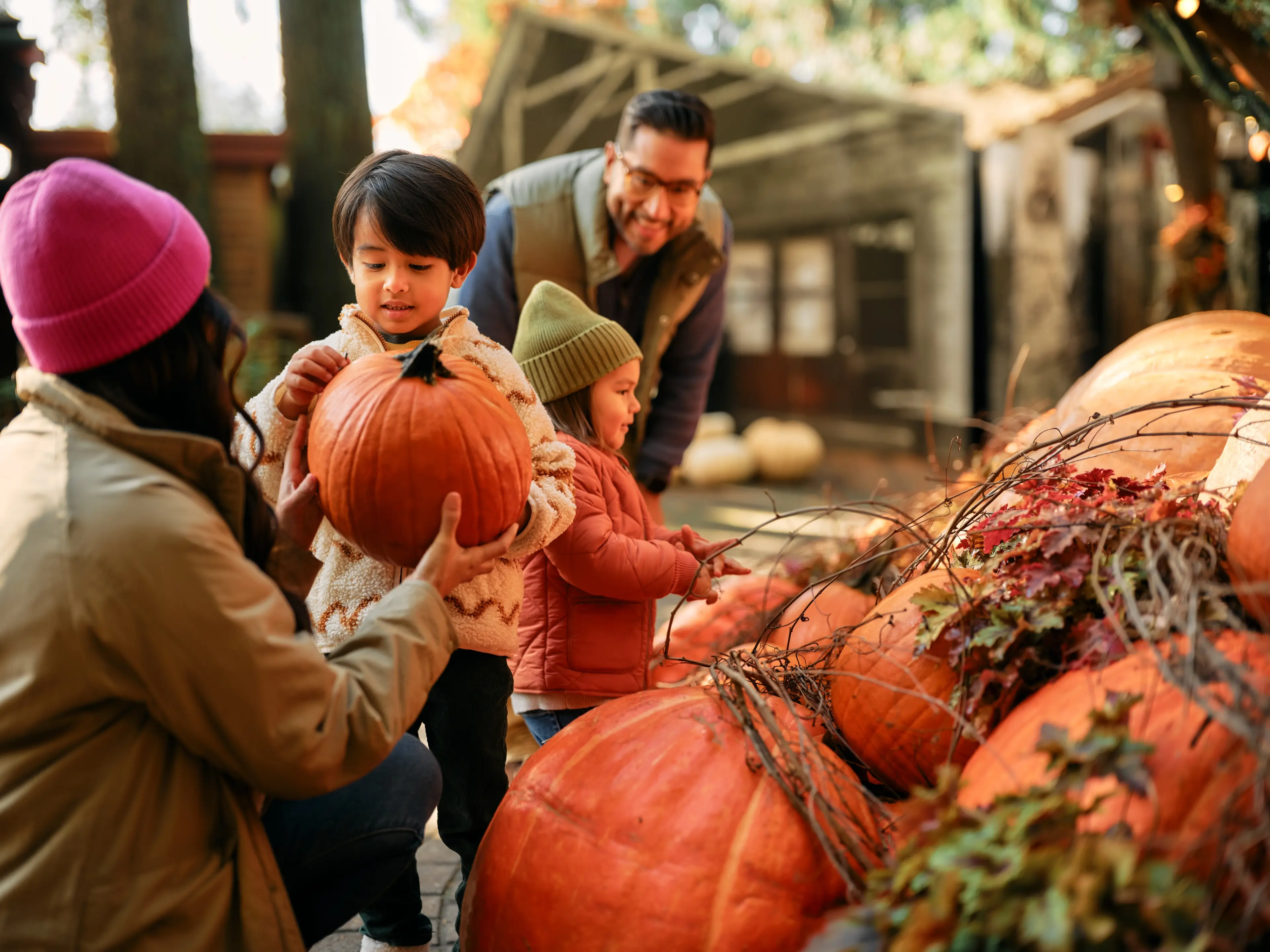 A family with two kids enjoying the pumpkin decorations at the Capilano Suspension Bridge Park in North Vancouver during Canyon Frights.