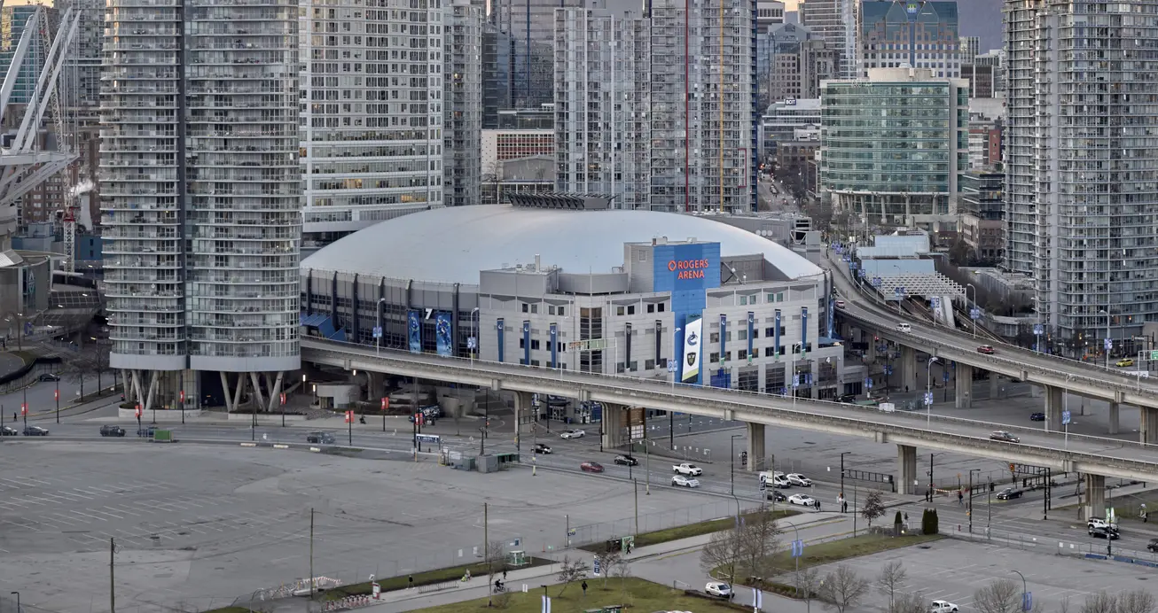 A concealed stadium is tucked in between buildings and raised highways.