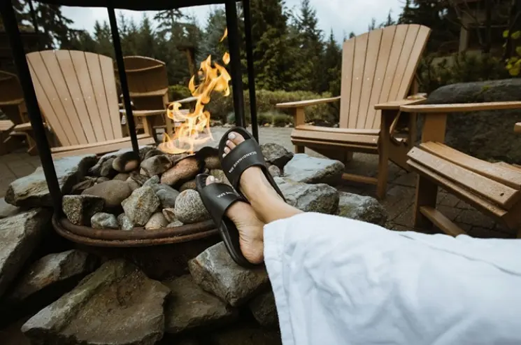 Person relaxing by a firepit at Scandinave Spa in Whistler. Spa retreats Vancouver.