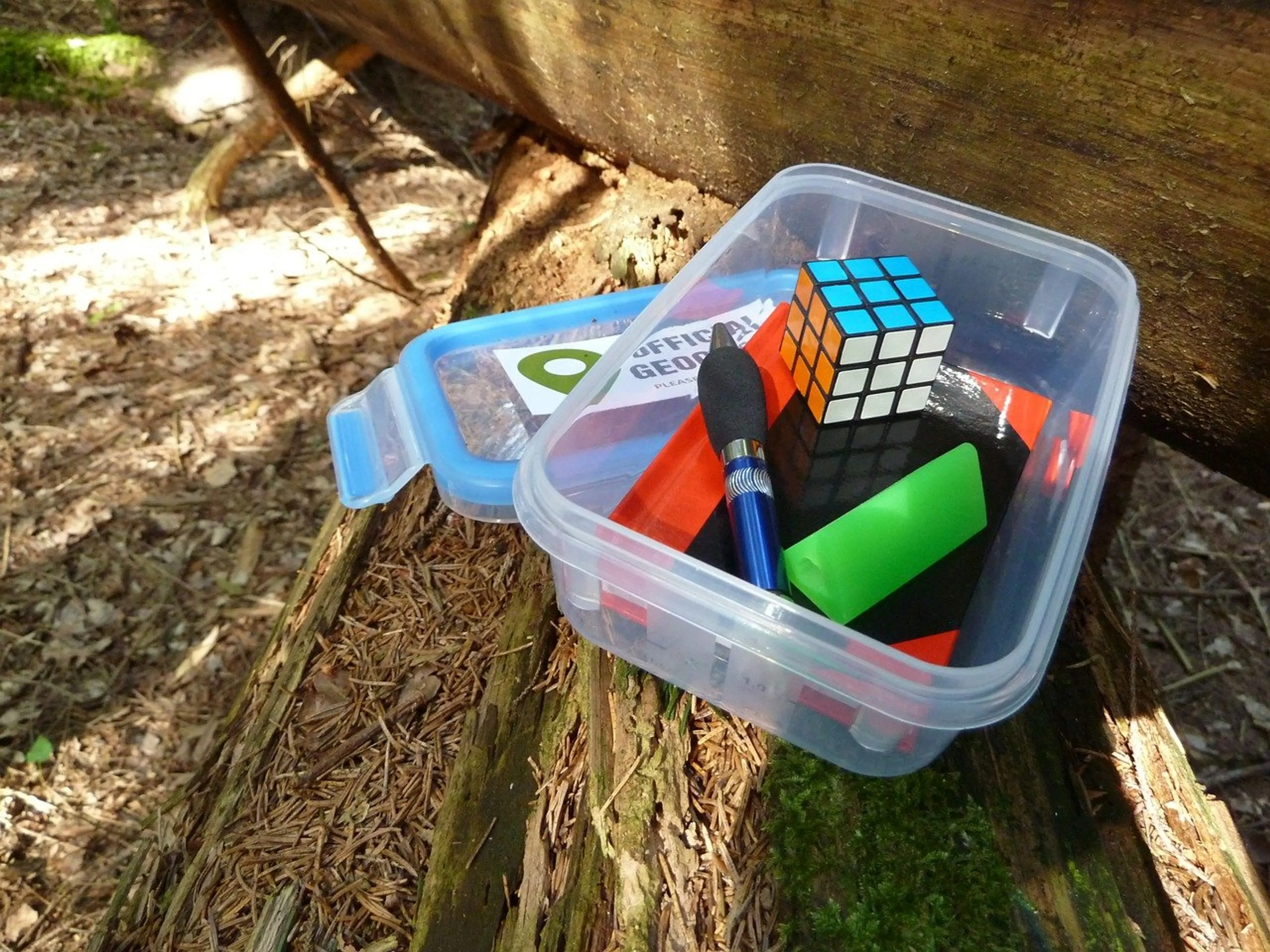 Open geocache with treasure inside.