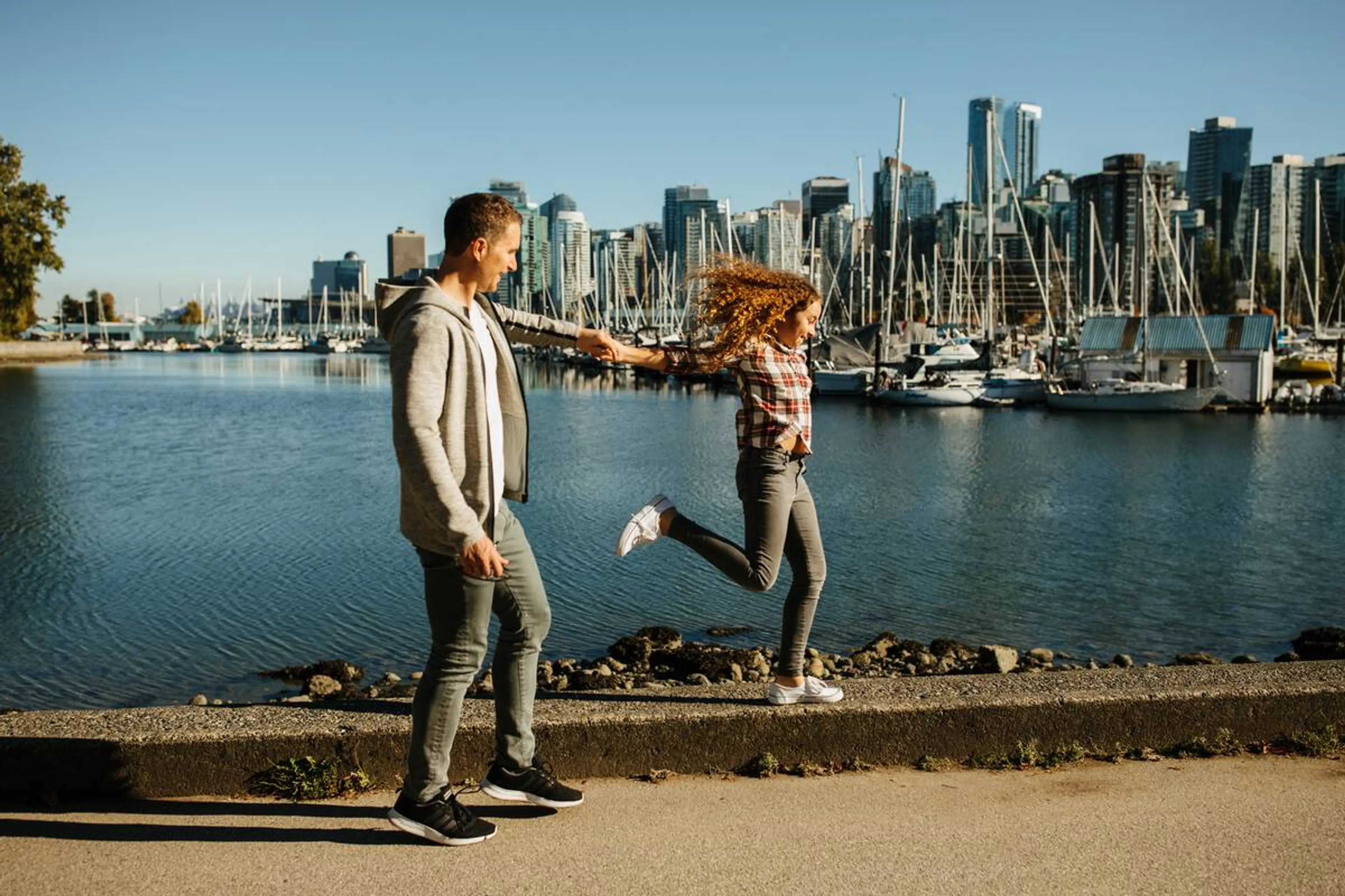 A father and daughter walking along the Stanley Park Seawall
