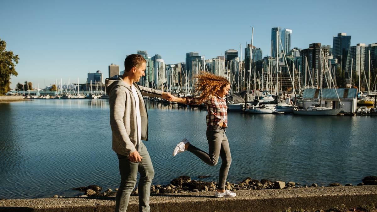 A father and daughter walking along the Stanley Park Seawall