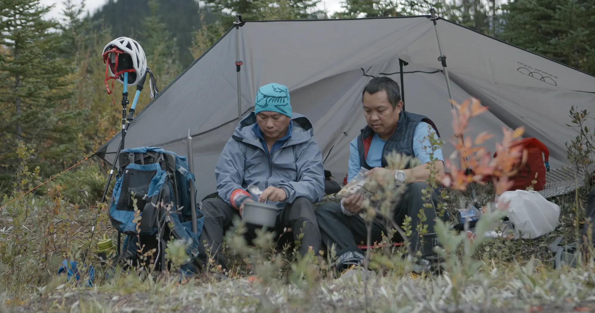 Two men sit under a tarp in a still from the film Ahon screening at the Vancouver International Mountain Film Festival
