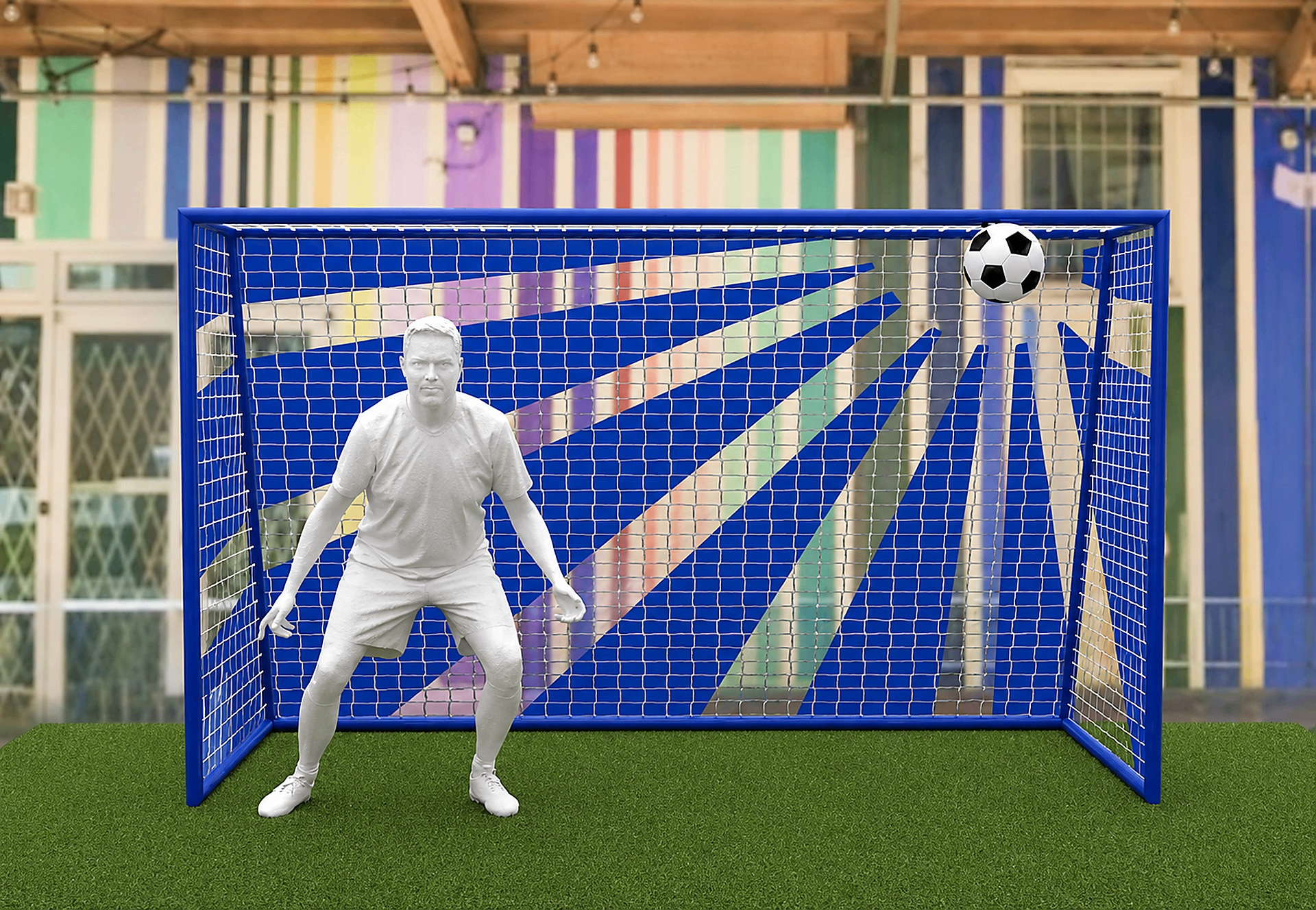 Person in a ready stance inside a blue soccer goal with a soccer ball hitting the top right corner of the net.