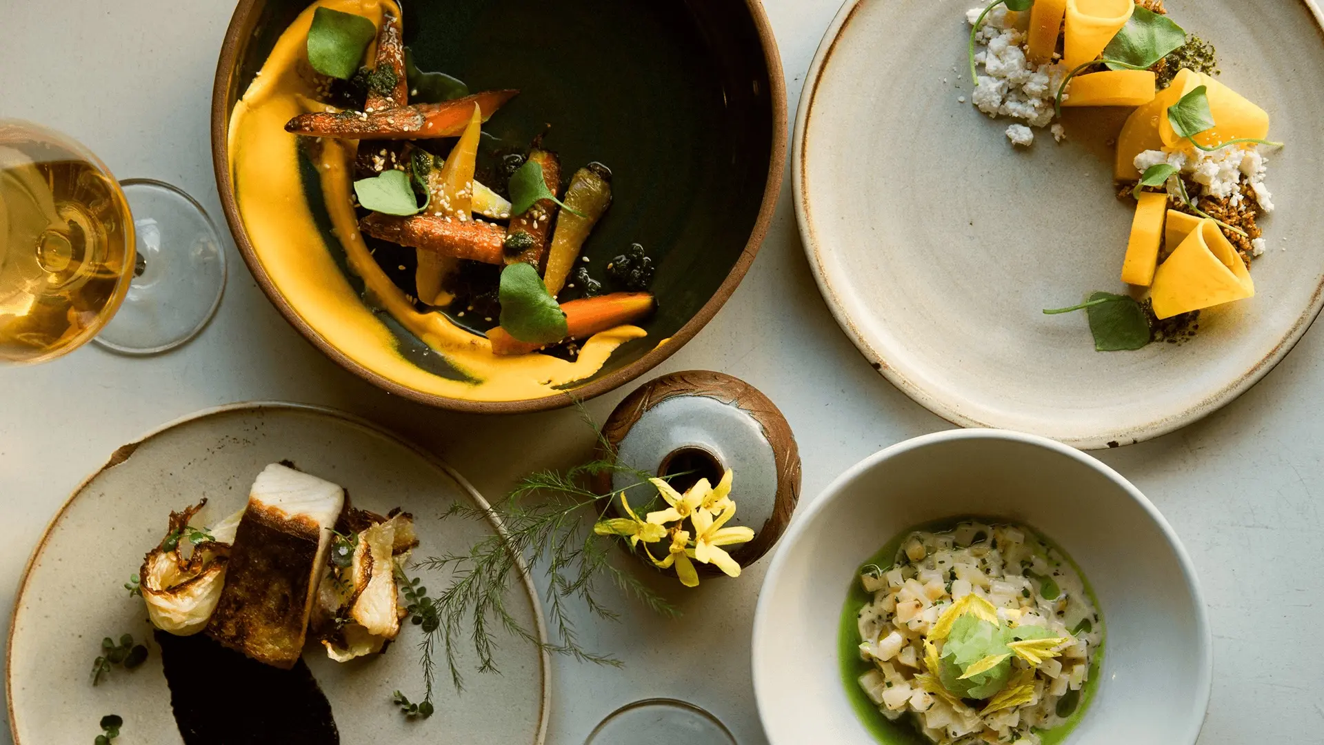 An overhead shot of artfully arranged plates of food at Farmer's Apprentice in Vancouver