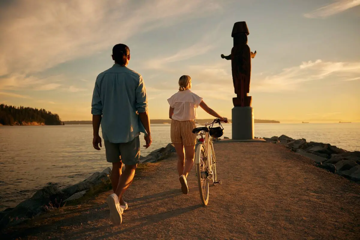 A couple explore Ambleside Park at sunset