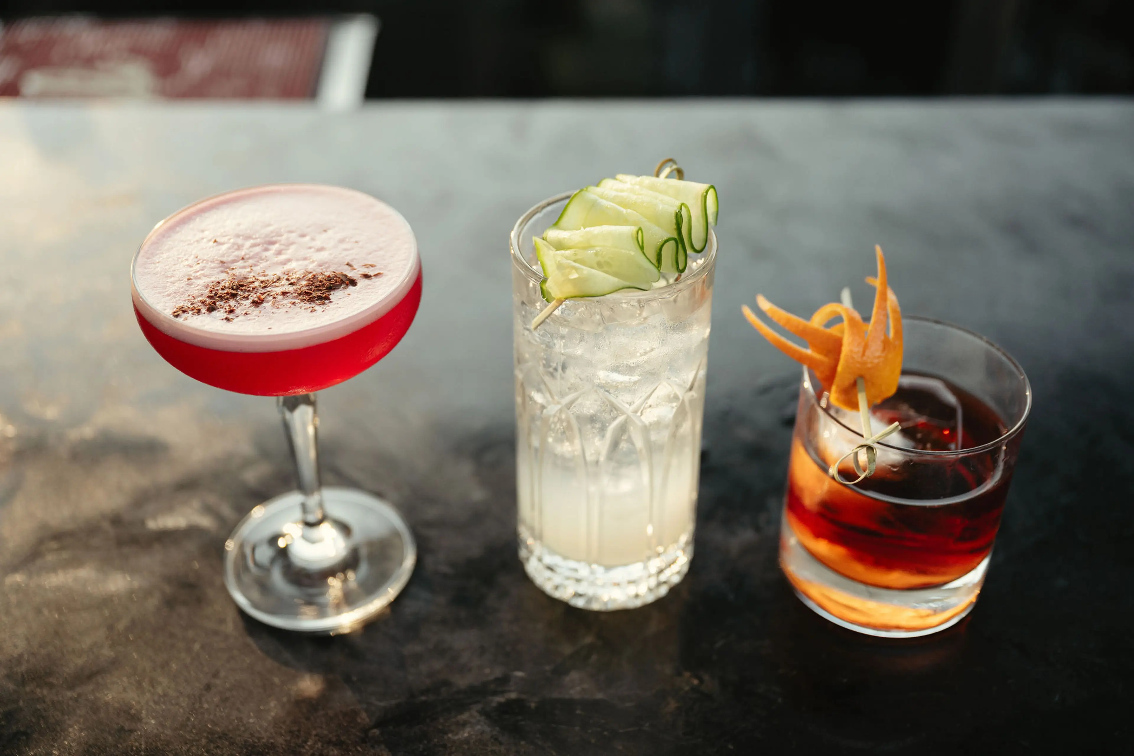 A selection of three cocktails. Each with a nice and colourful garnish.