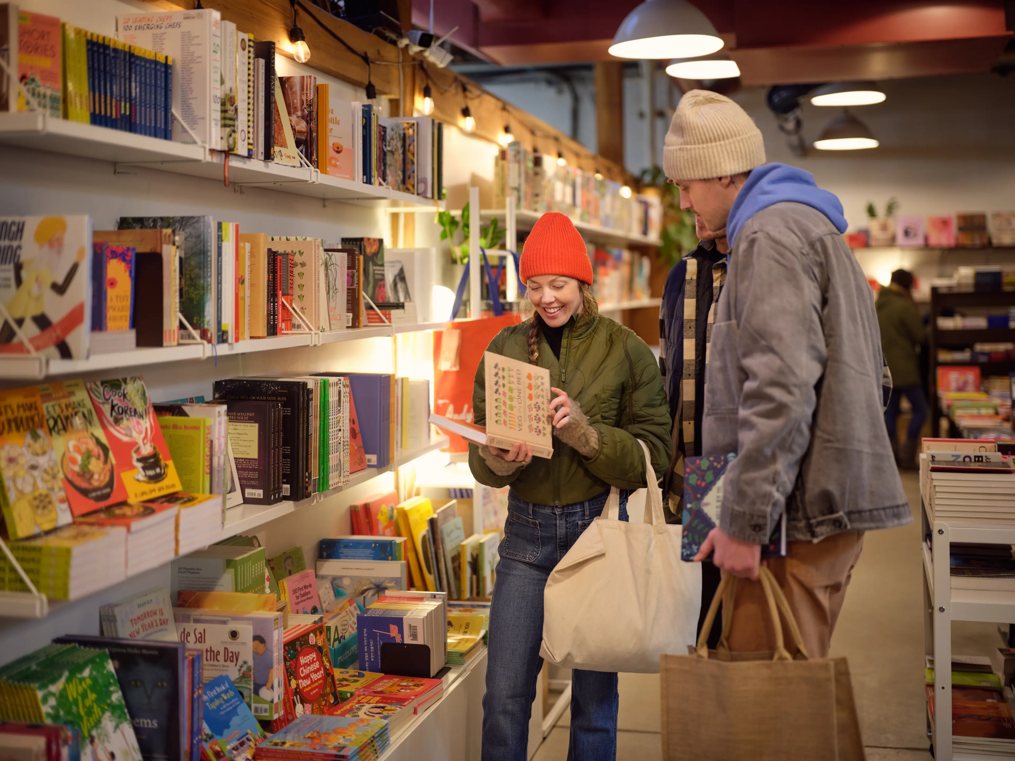 Two young people shopping at the Nooroongji Books shop on Granville Island in Vancouver.