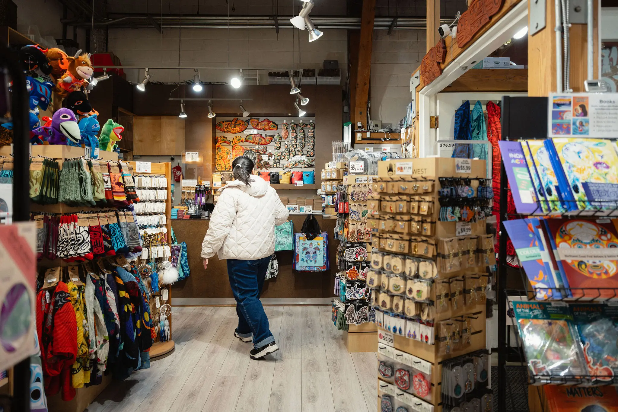 Interior image of the Wickaninnish Gallery Ltd on Granville Island in Vancouver with a person shopping.