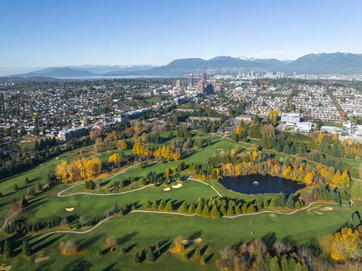 An aerial view of Langara Golf Course surrounded by the city of Vancouver with the North Shore Mountains in the background.
