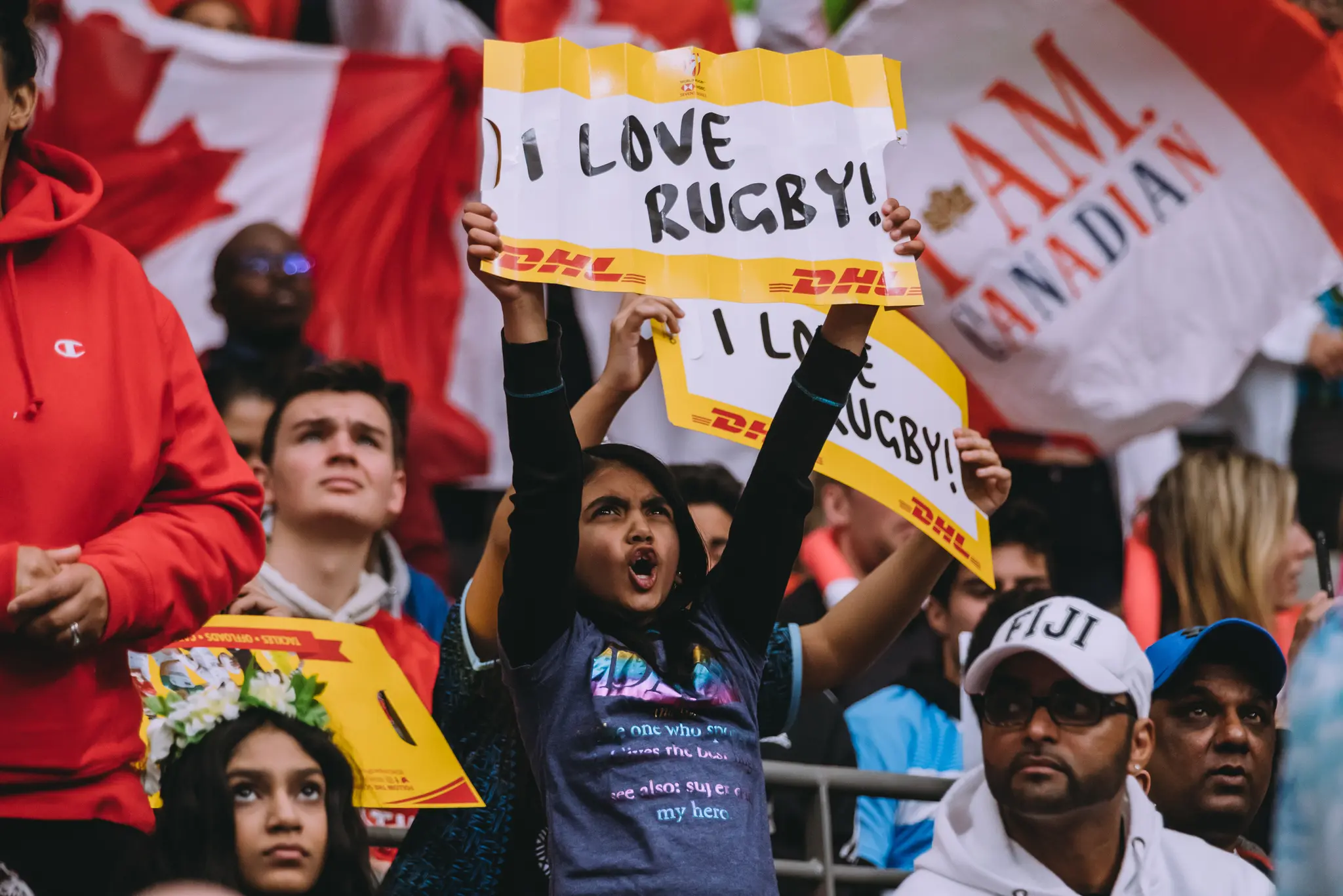 Rugby fans cheering in the stands with signs