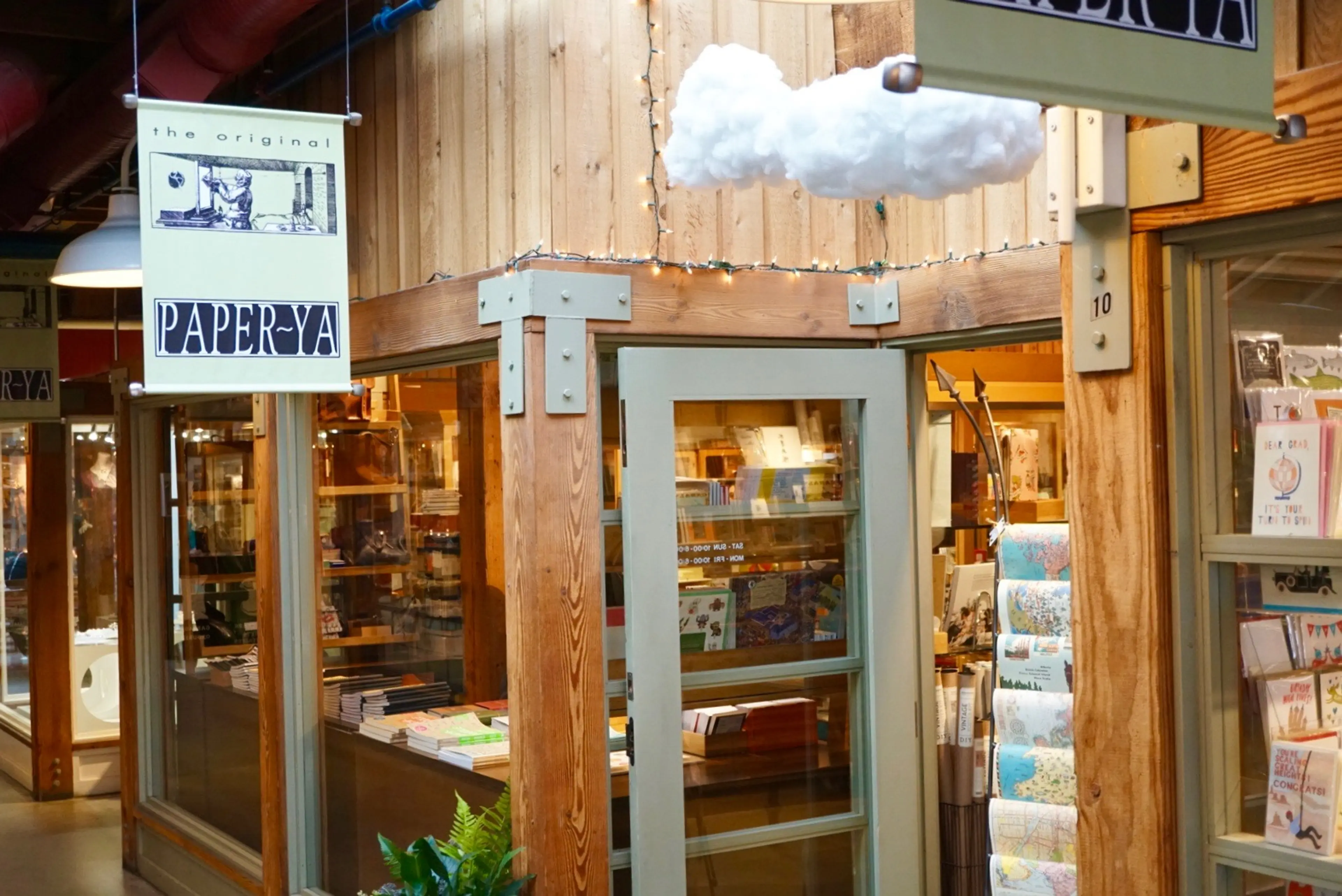 The exterior of Paper-Ya on Granville Island with racks of greeting cards and wrapping paper on display.