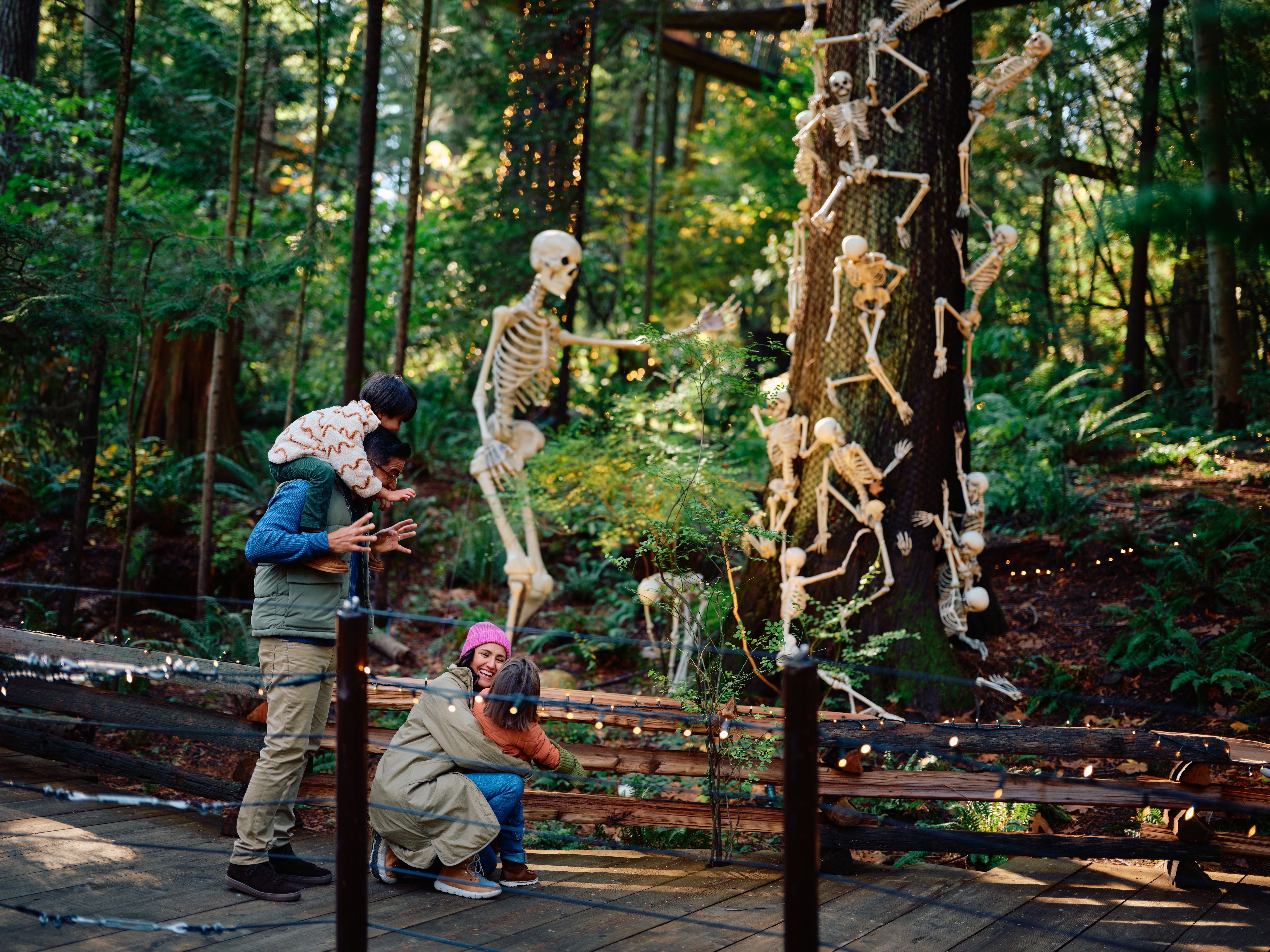 A family having fun with Halloween skeleton decoration at the Canyon Frights event at the Capilano Suspension Bridge Park in North Vancouver.