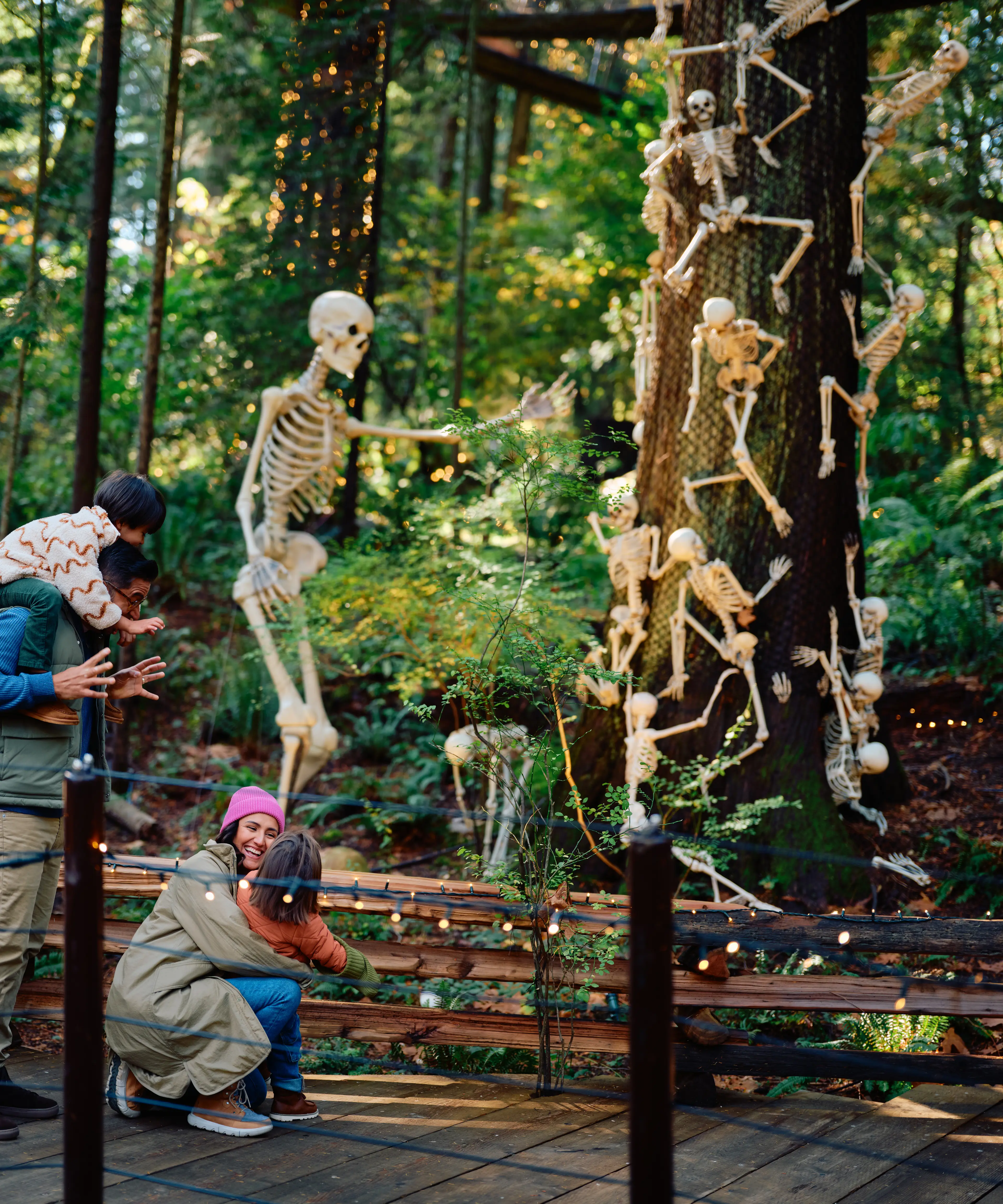 A family having fun with Halloween skeleton decoration at the Canyon Frights event at the Capilano Suspension Bridge Park in North Vancouver.