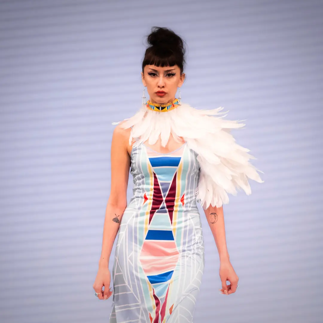 Model wearing Choke Cherry Creek (feathered neckpiece and a sleeveless multicoloured dress))