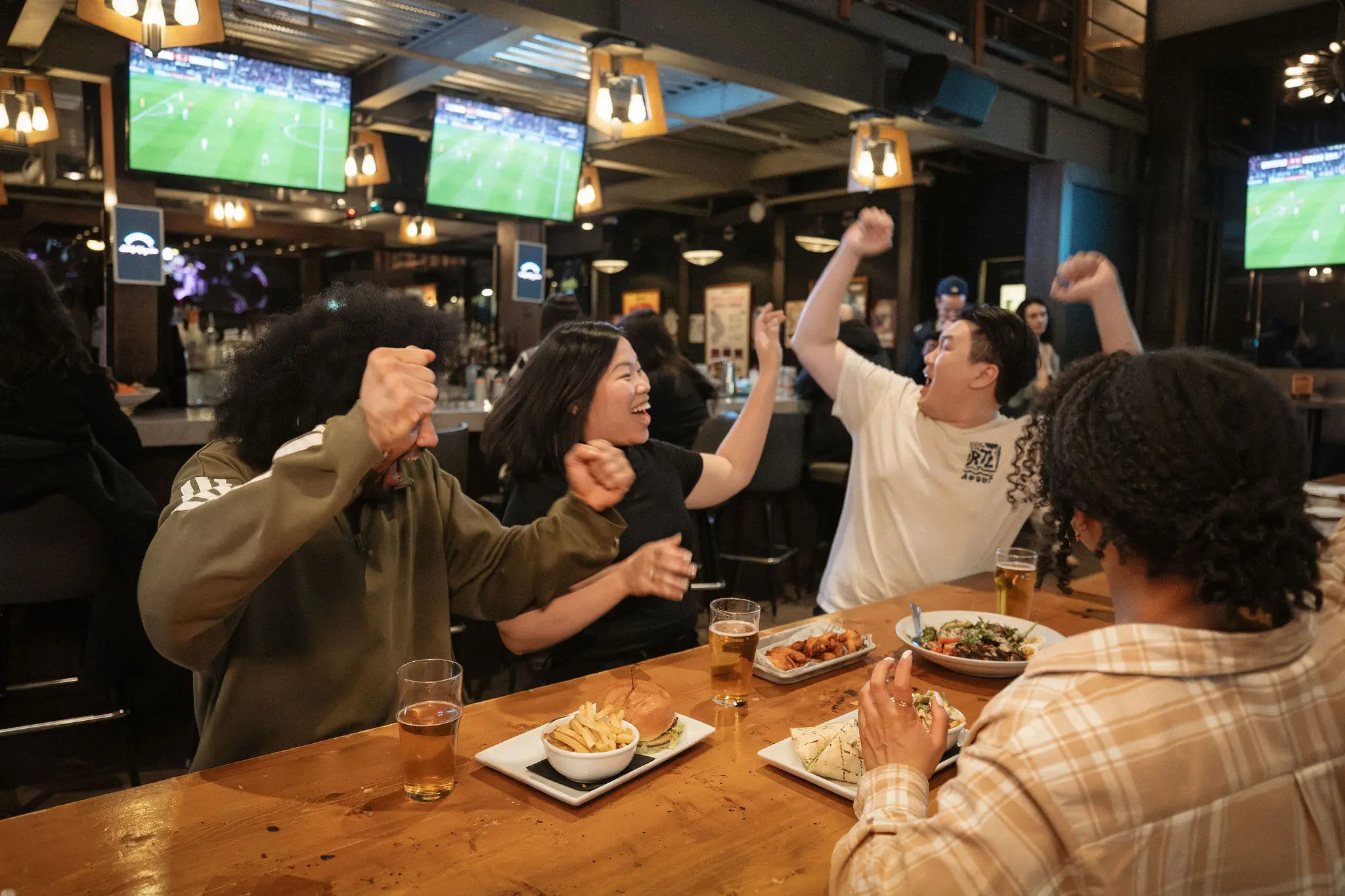 People cheering at the Good Co bar in Vancouver.