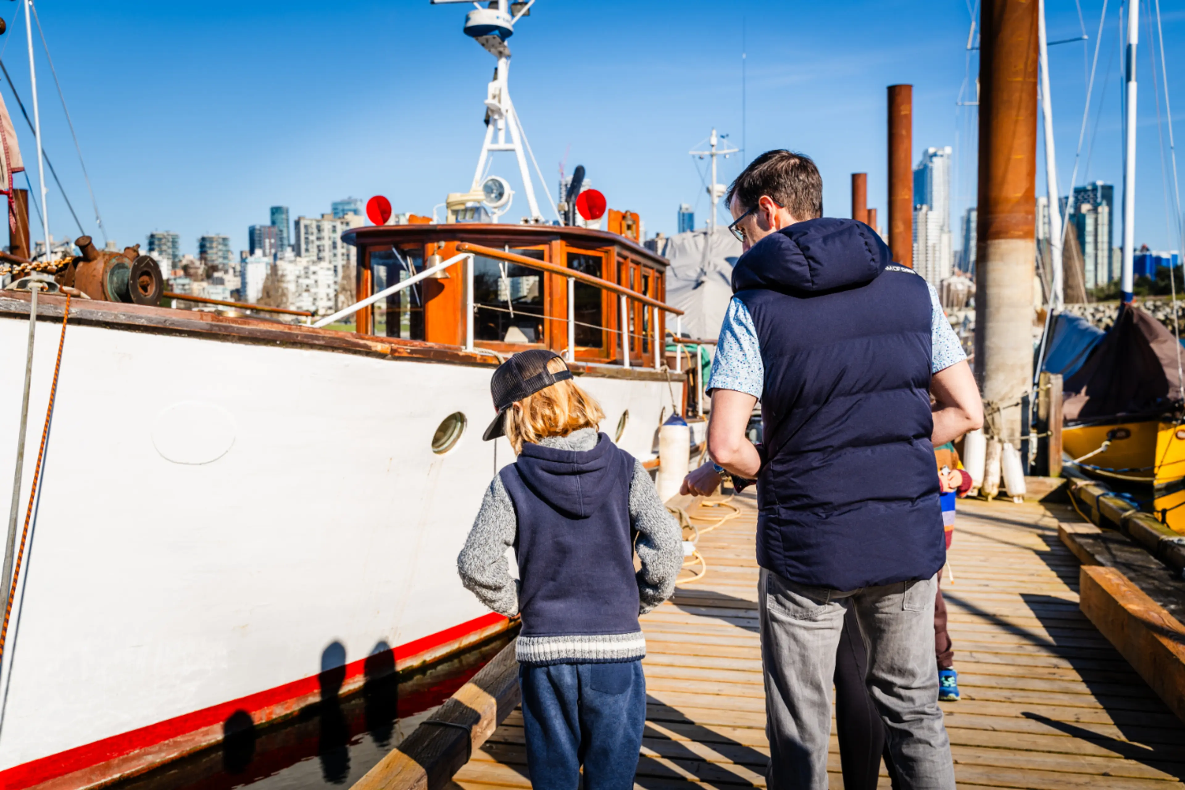 A father and son walk between boats at Heritage Harbour at the Vancouver Maritime Museum