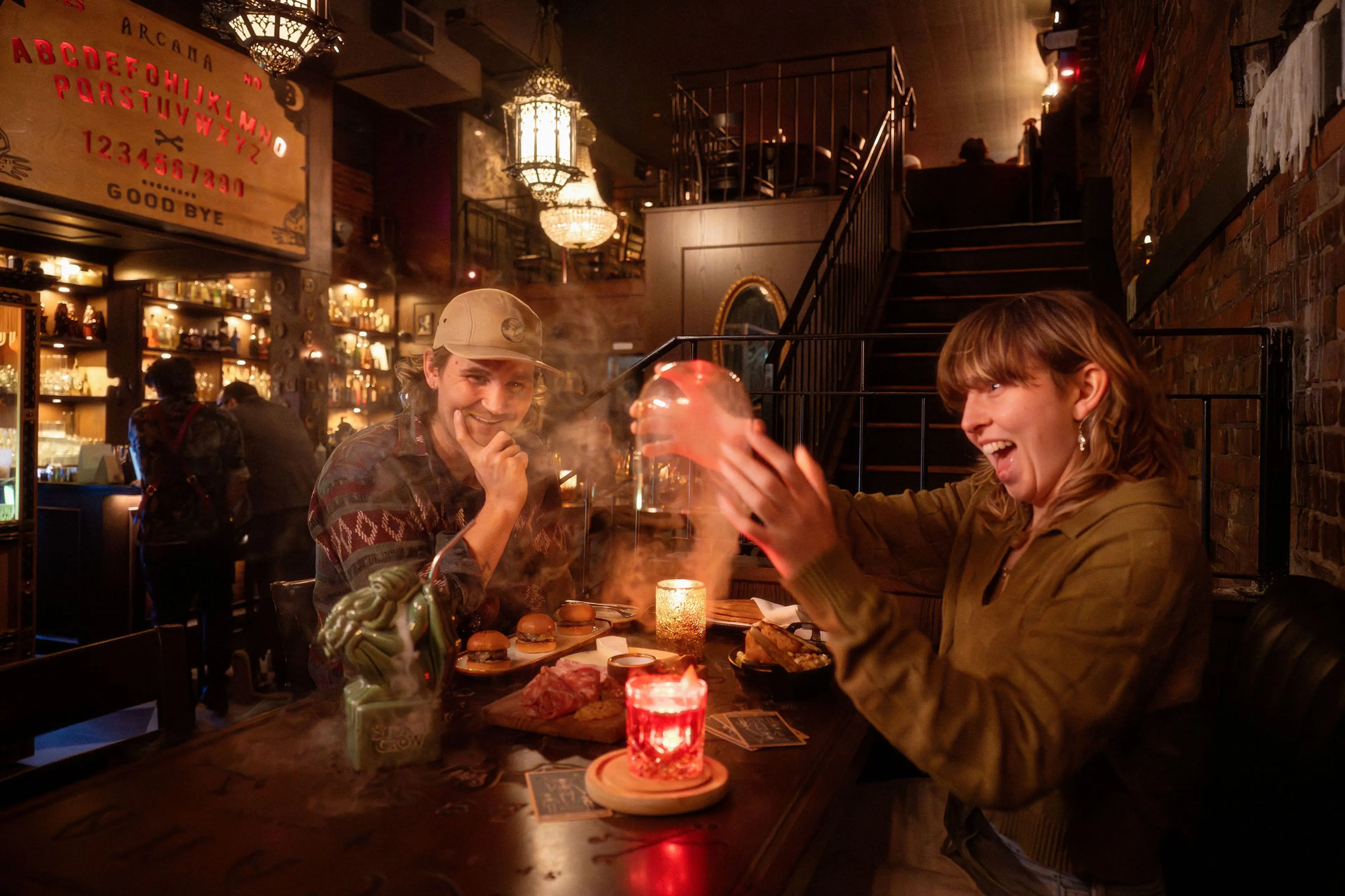 Two people being surprised about their steaming cocktails at Arcana Food and Spirits in Vancouver.