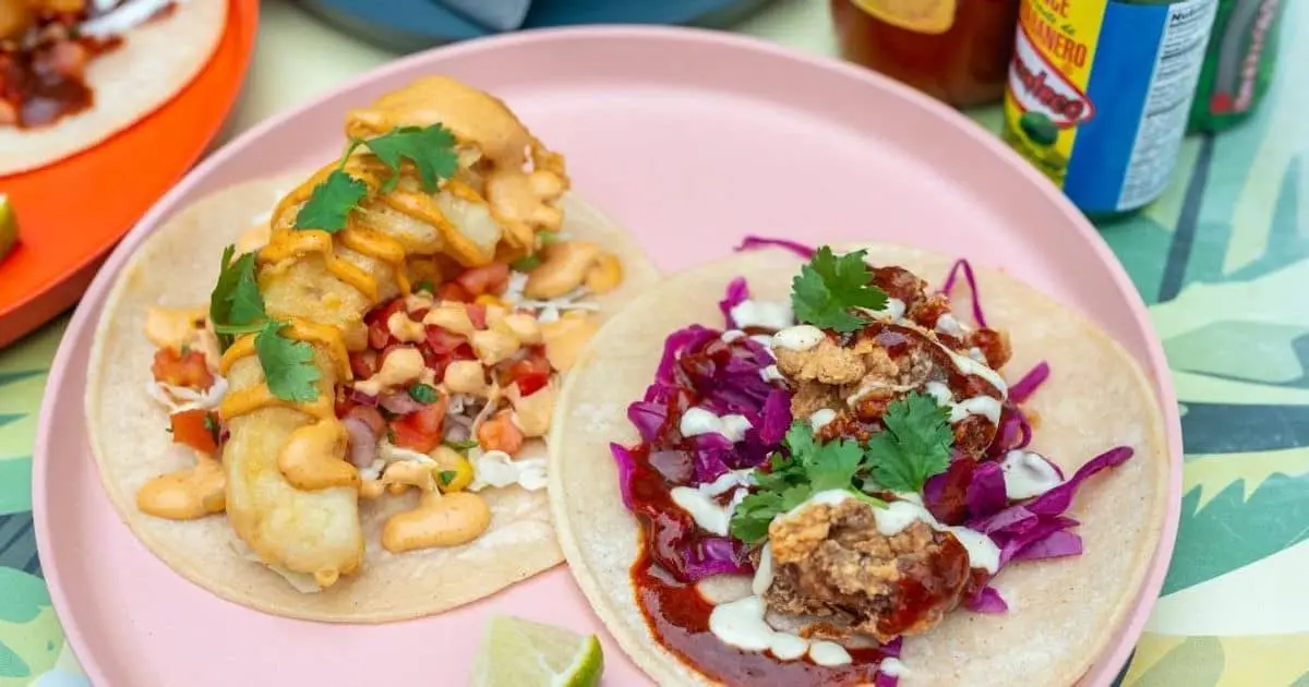 fish and meat soft tacos on a pink plate