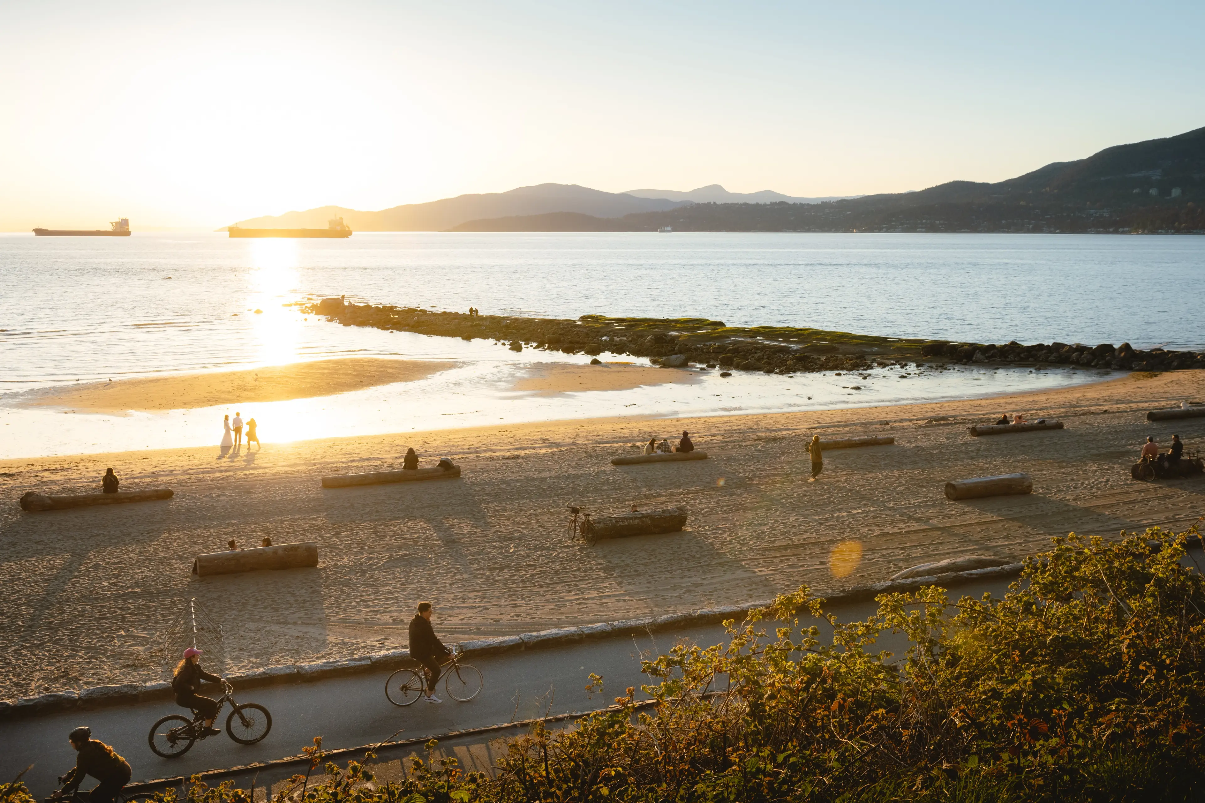 People picnic on Third Beach in Stanley Park at sunset. 
