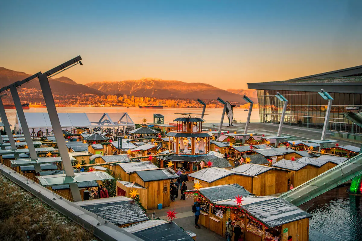 An aerial view of the Vancouver Christmas Market at dusk with the North Shore mountains in the background.