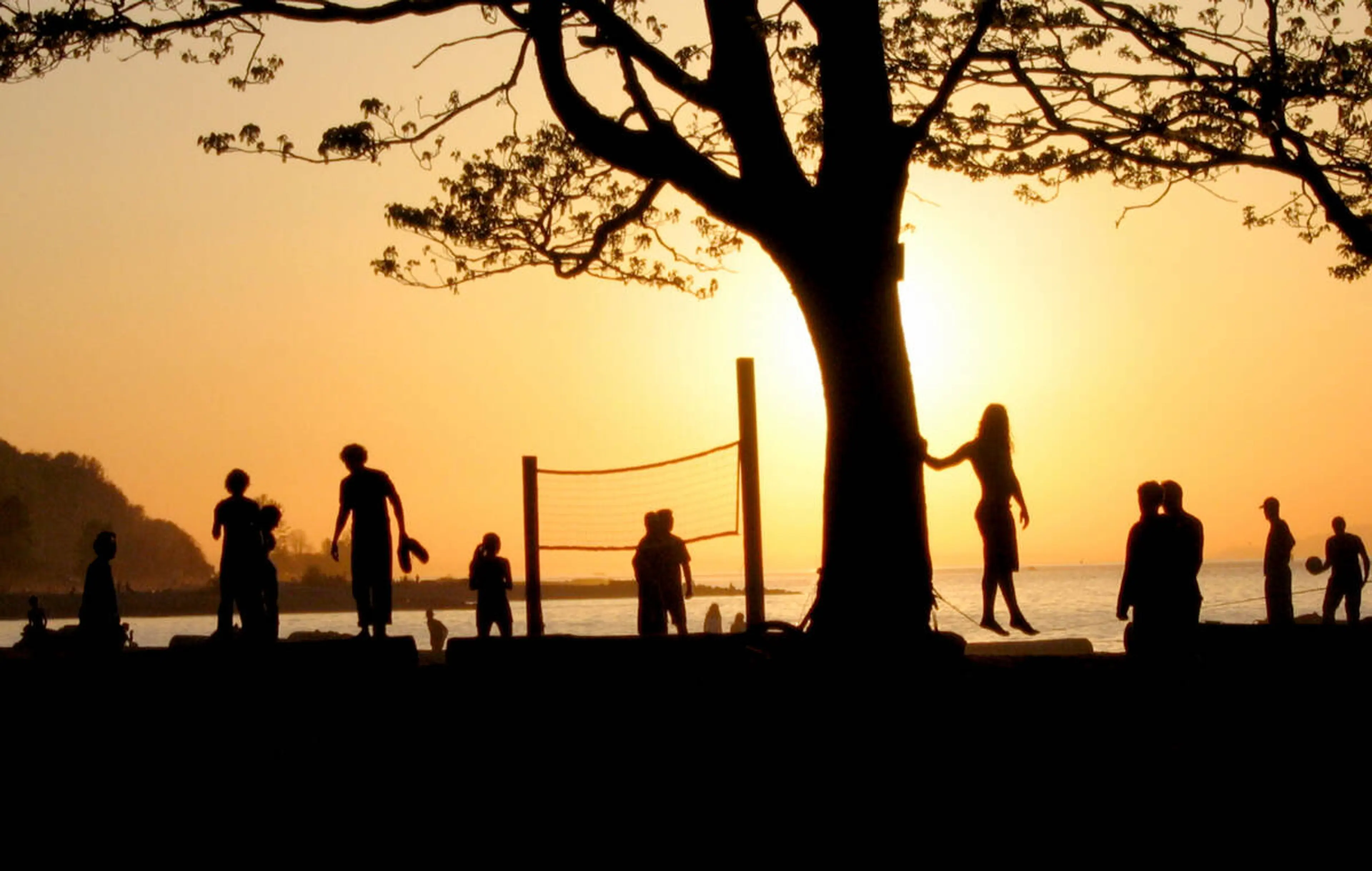 People play volleyball at sunset at Kits Beach 