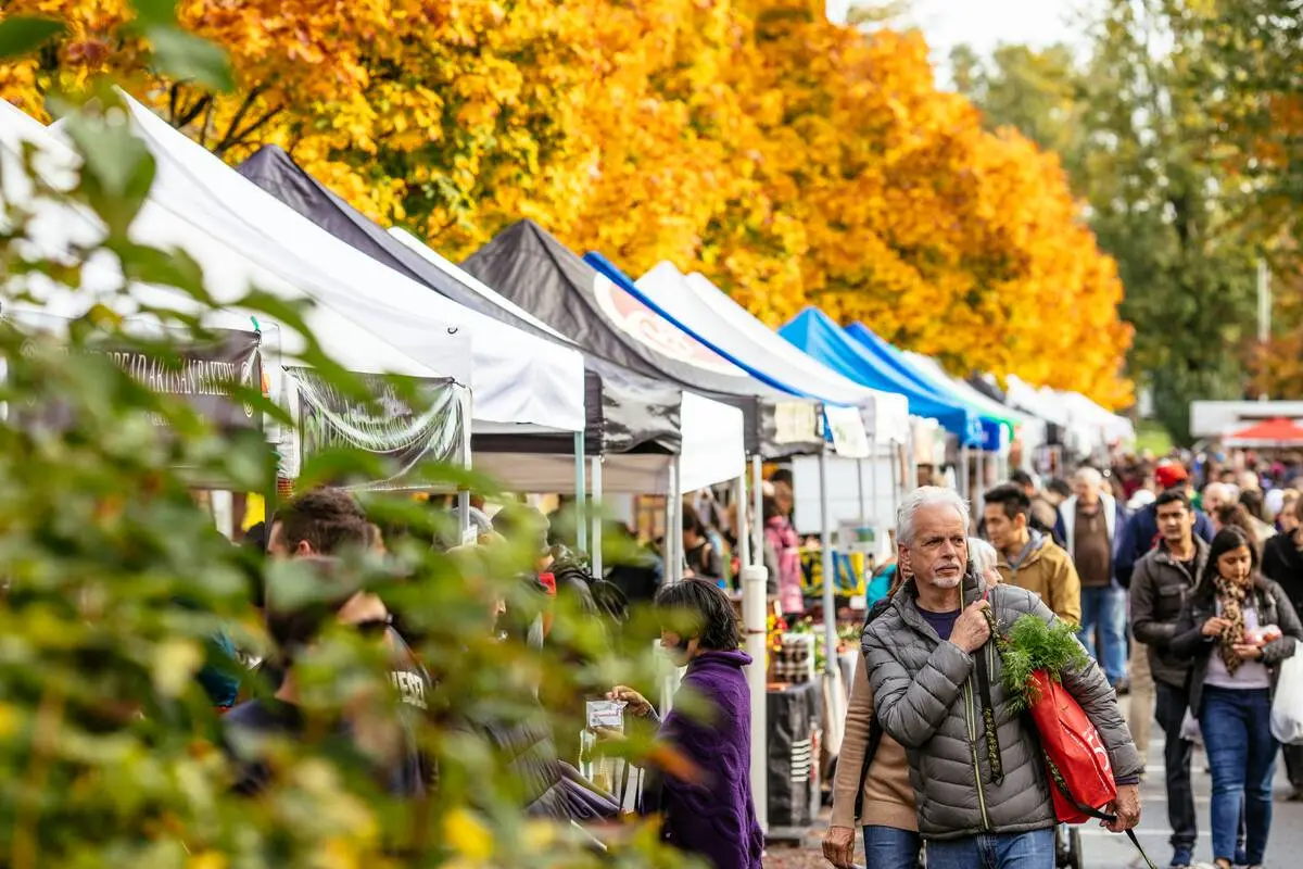 People strolling the Trout Lake Farmer's Market in fall in Vancouver.