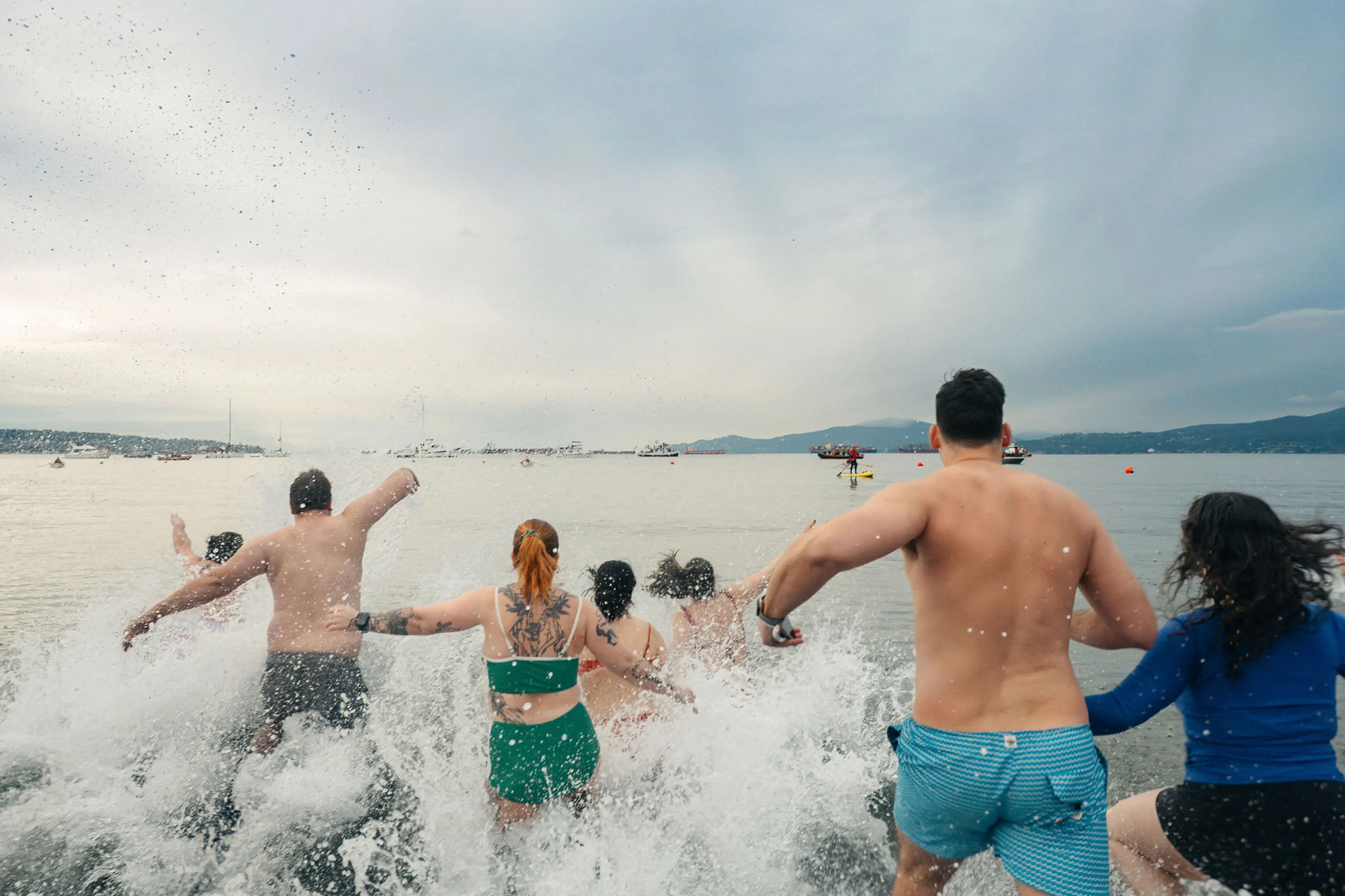 People running into the water at the Polar Bear Swim in Vancouver.