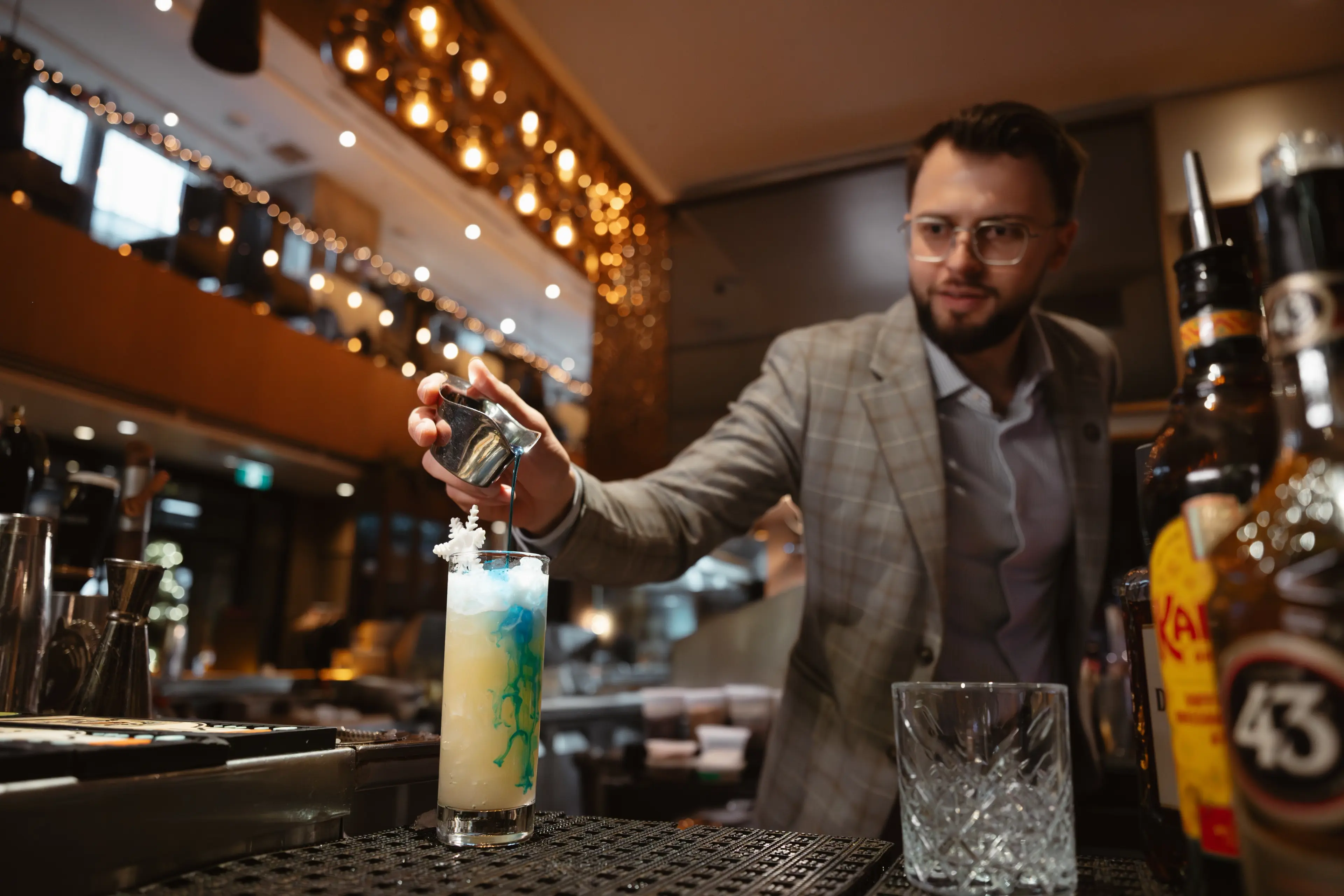 A person preparing a cocktail at the bar at the restaurant Glowbal in Vancouver.