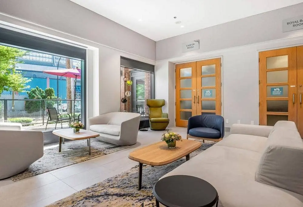 Modern interior with wooden double doors, stylish seating area, and street level porch.