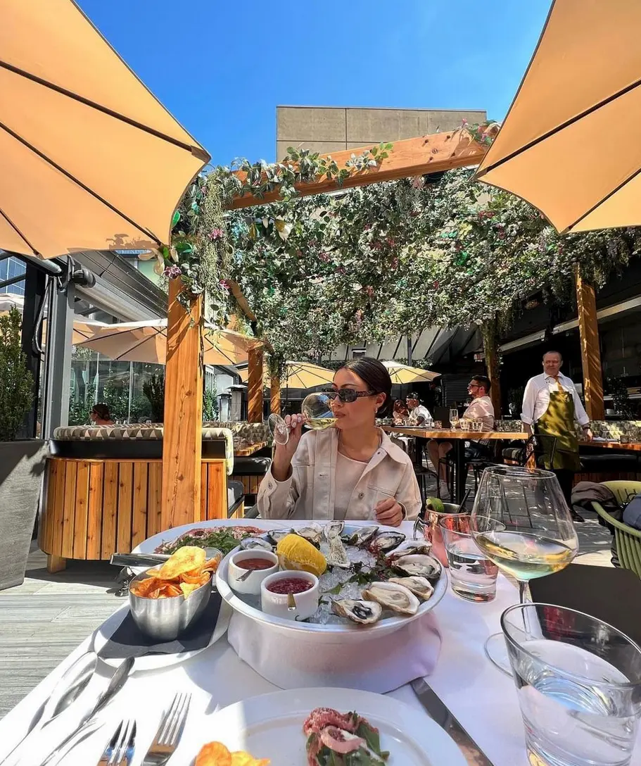 A woman enjoys seafood at The Roof at Black and Blue