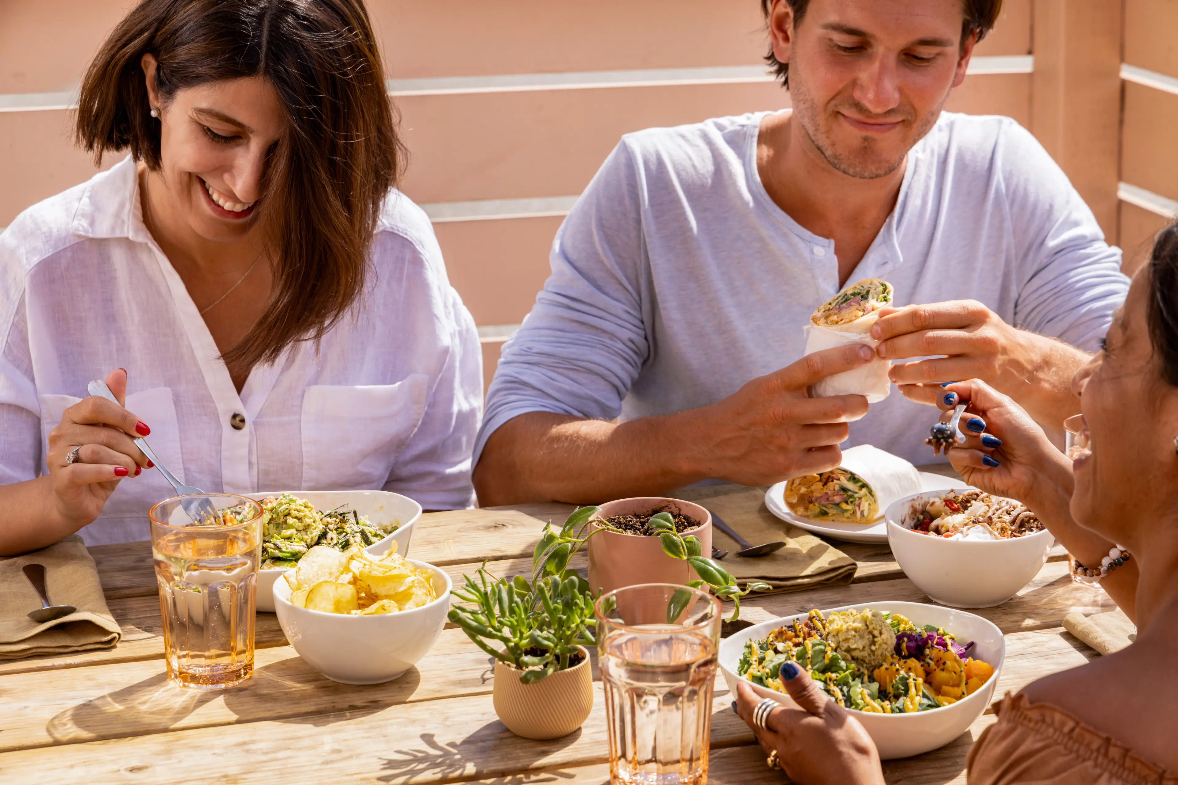 Three friends dig in to healthy vegan lunch at Kokomo in Vancouver