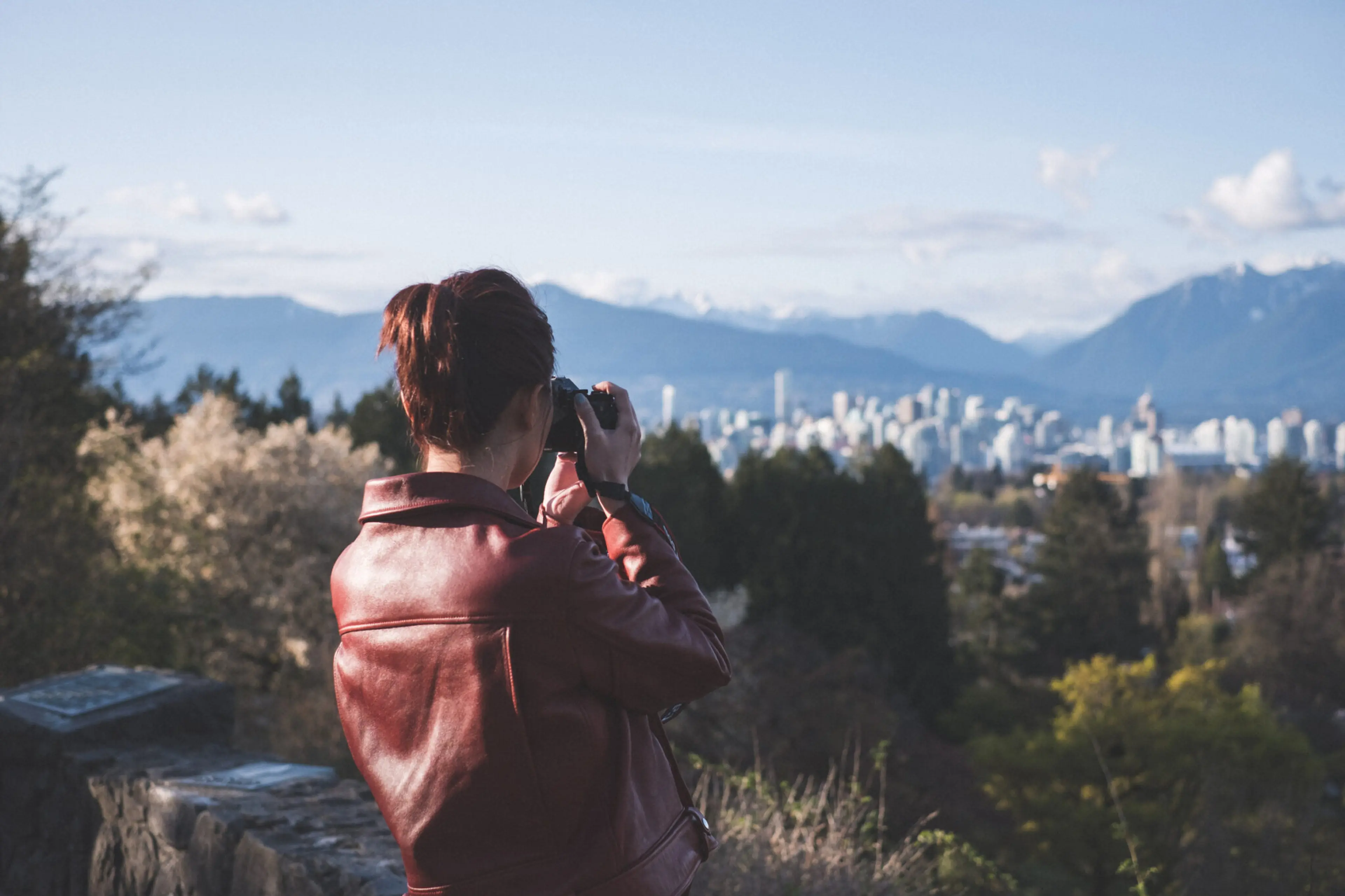 A woman takes a photo at Queen Elizabeth Park in Vancouver