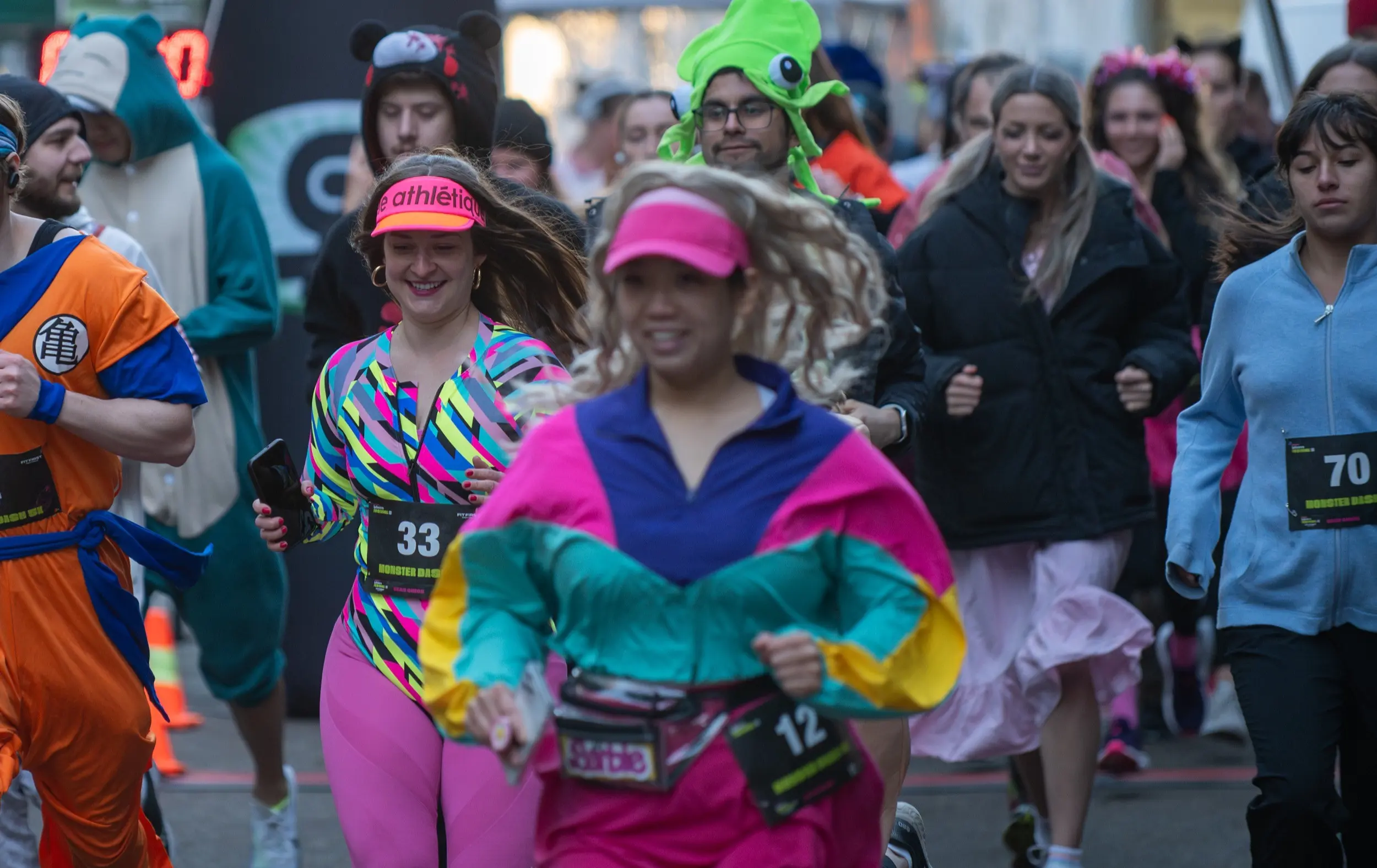 Group of people running in colorful and costume outfits during a race event.
