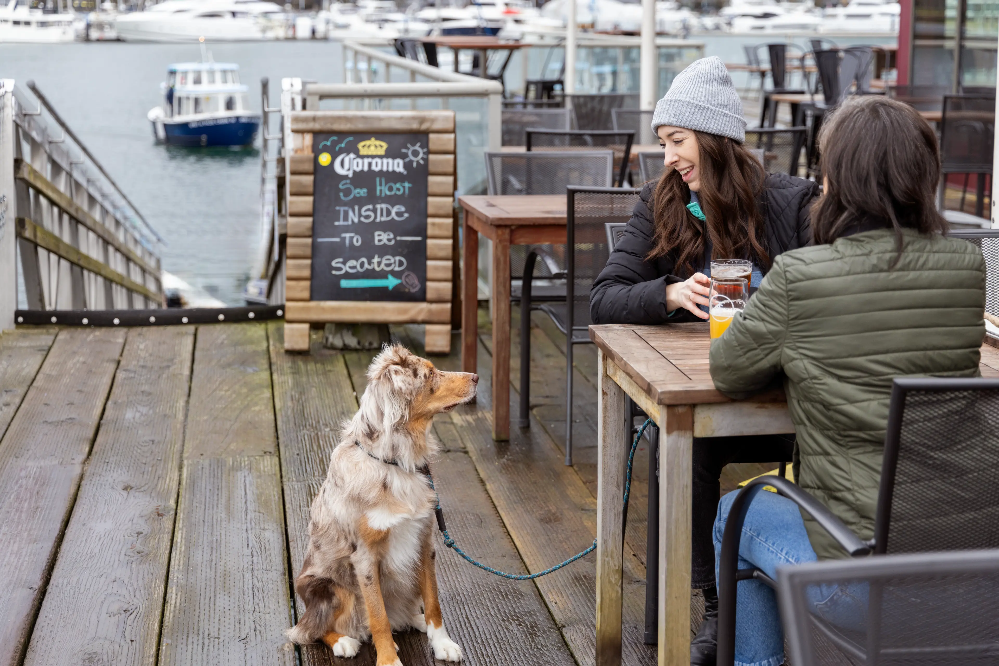 A couple sitting with their dog on a brewery patio in Vancouver.