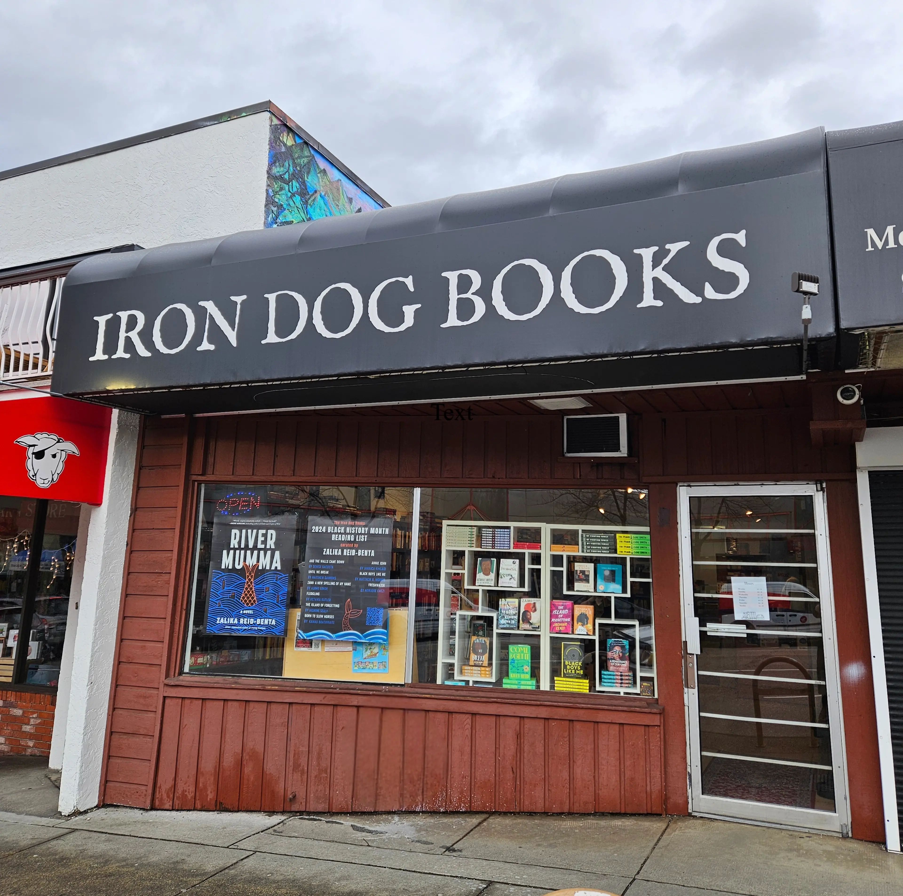 The exterior of Iron Dog Books in Vancouver. There are books and book posters in the window.