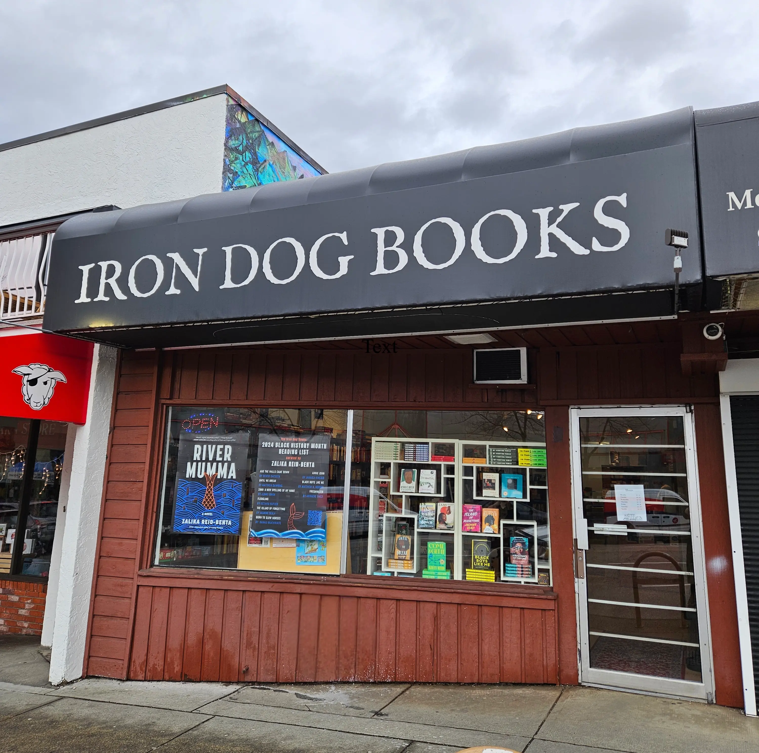 The exterior of Iron Dog Books in Vancouver. There are books and book posters in the window.
