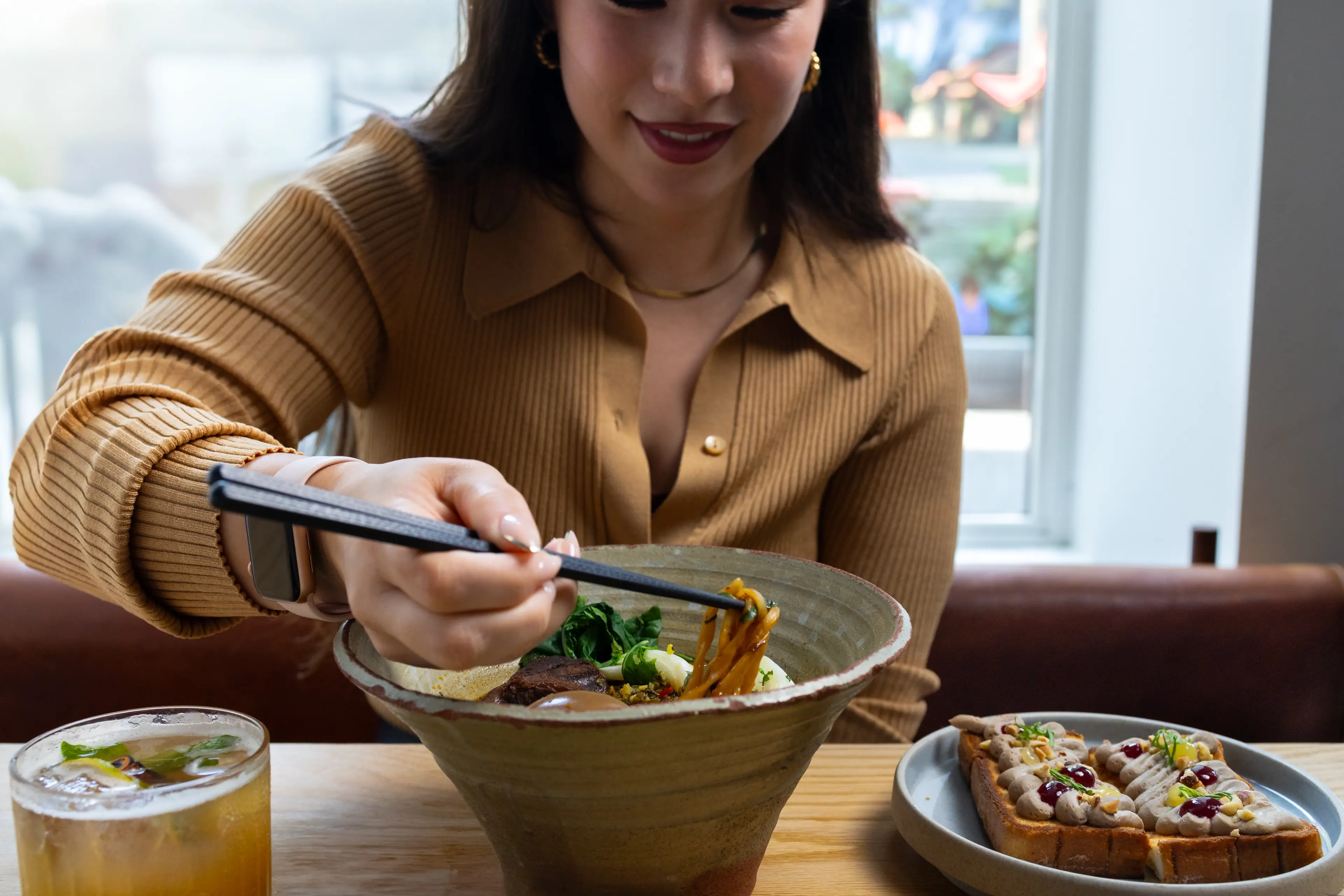 A young women eating ramen soup at the restaurant Torafuku in Vancouver. 