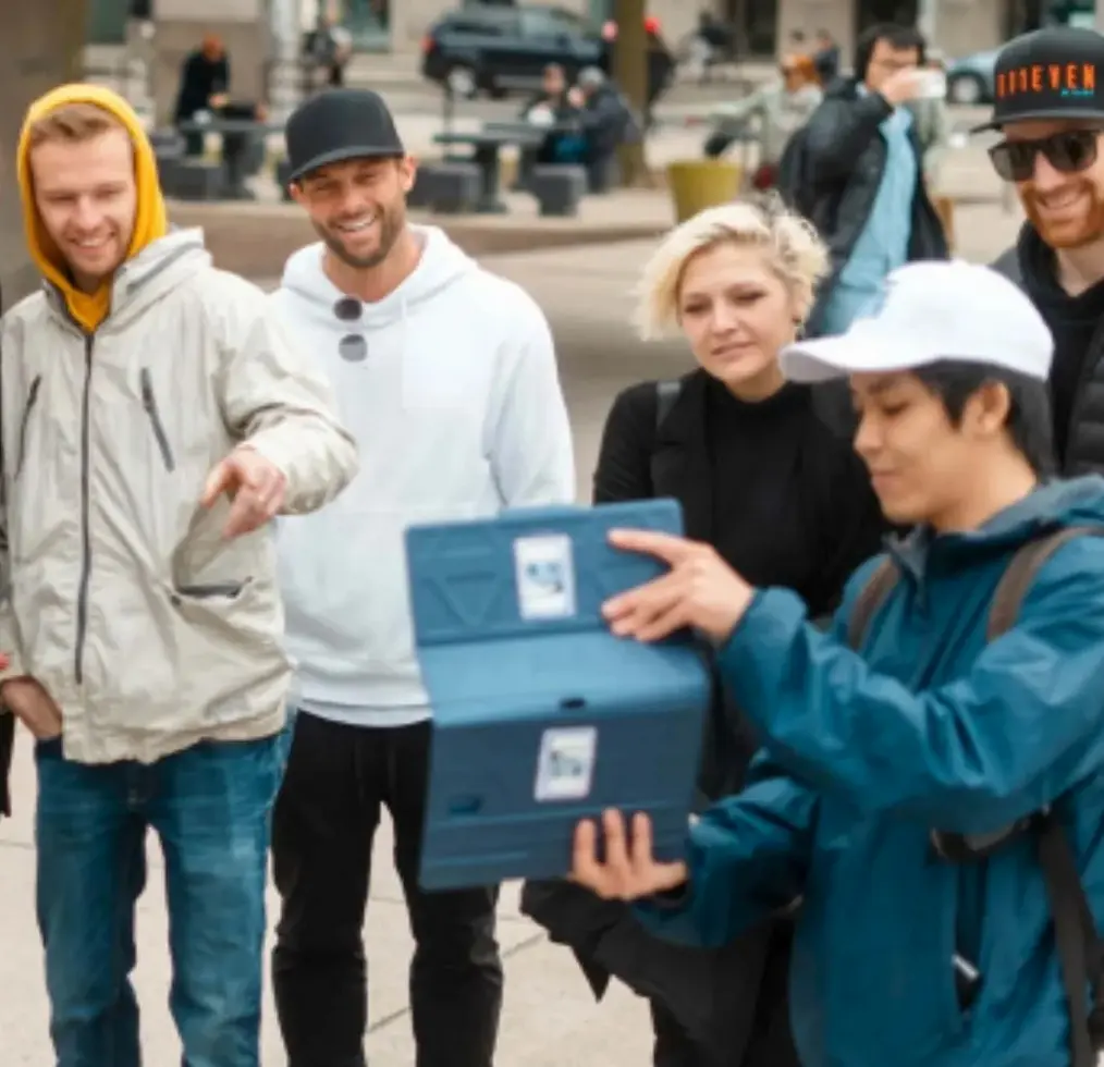 A group watches a clip of a film on an ipad with a tour guide from Vancouver Film and TV Tours