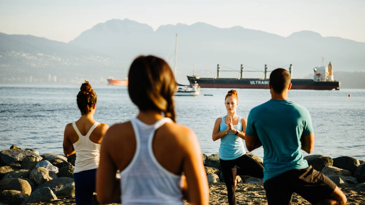 People doing yoga on the beach.