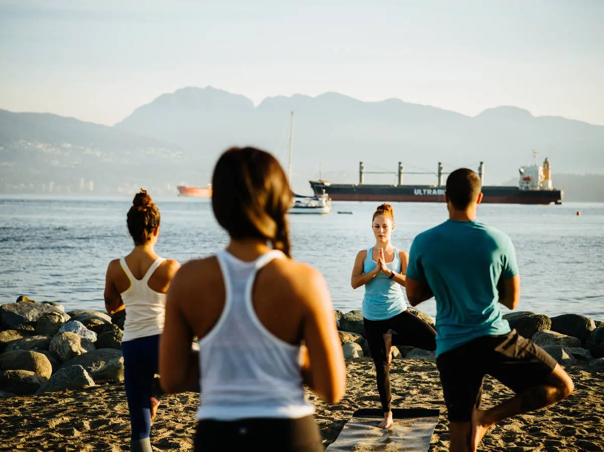 People doing yoga on the beach.